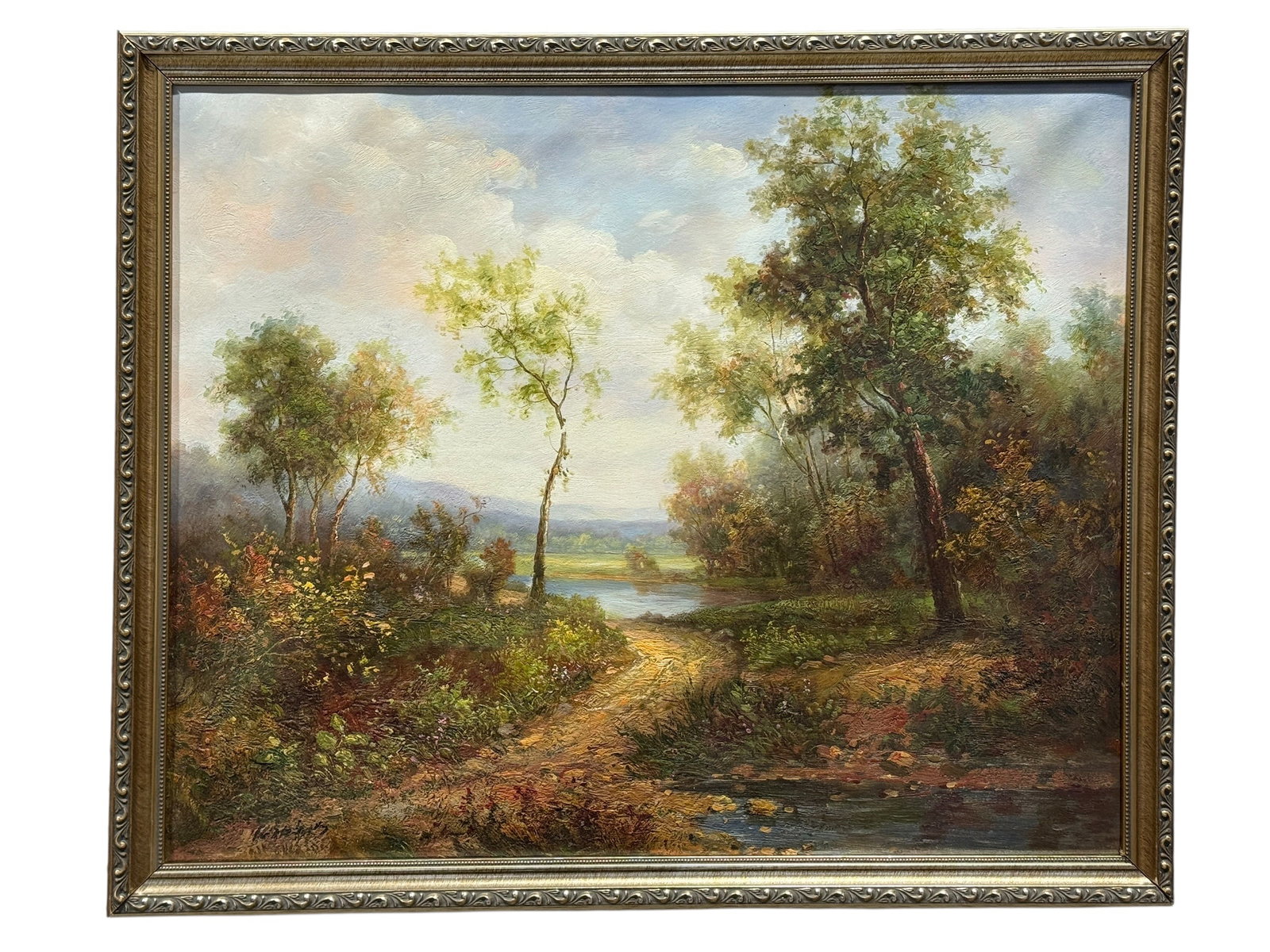 Signed Oil on Canvas Woodland River Landscape w/ Distant Mountains: A warmly atmospheric woodland vista unfolds around a quiet river in this richly textured oil on canvas, drawing the eye along a sunlit earthen path toward calm water, open meadows, and hazy blue mount