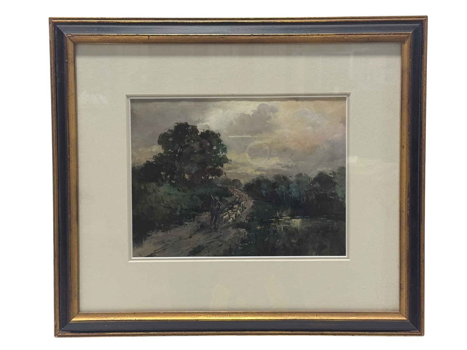 Signed C.B. Olive 19th C. Pastoral Watercolor Landscape: A richly atmospheric 19th century pastoral landscape centered on a shepherd guiding a clustered flock of sheep along a winding country road beside still water, with dense trees and heavy cloud cover