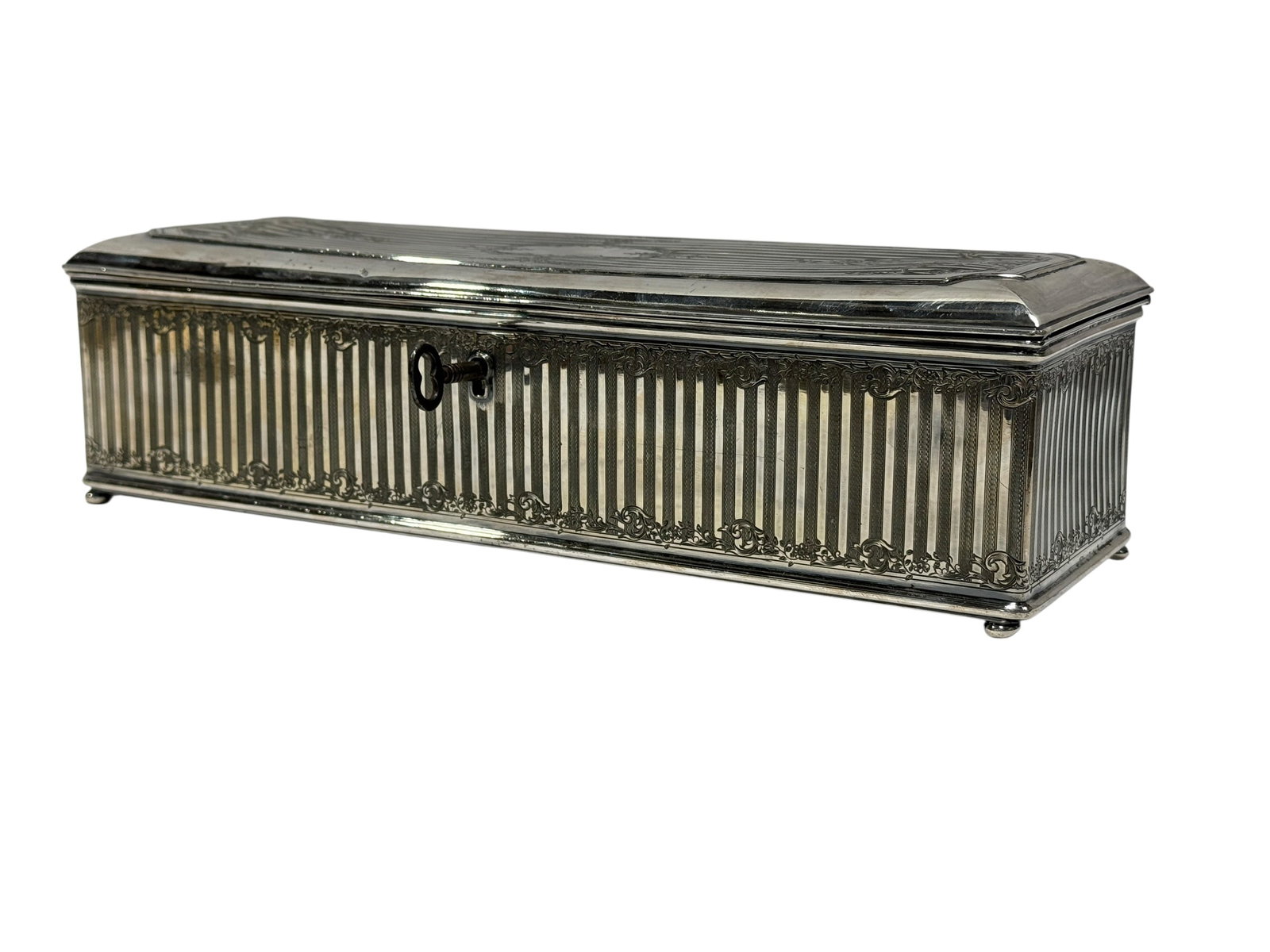 Wilcox Silver Plate Co. 19th Century Engraved Silverplate Jewelry Box: Fine late 19th century silverplate jewelry or trinket box by Wilcox Silver Plate Co., designed in an elongated rectangular casket form raised on small rounded feet and retaining its original key. The