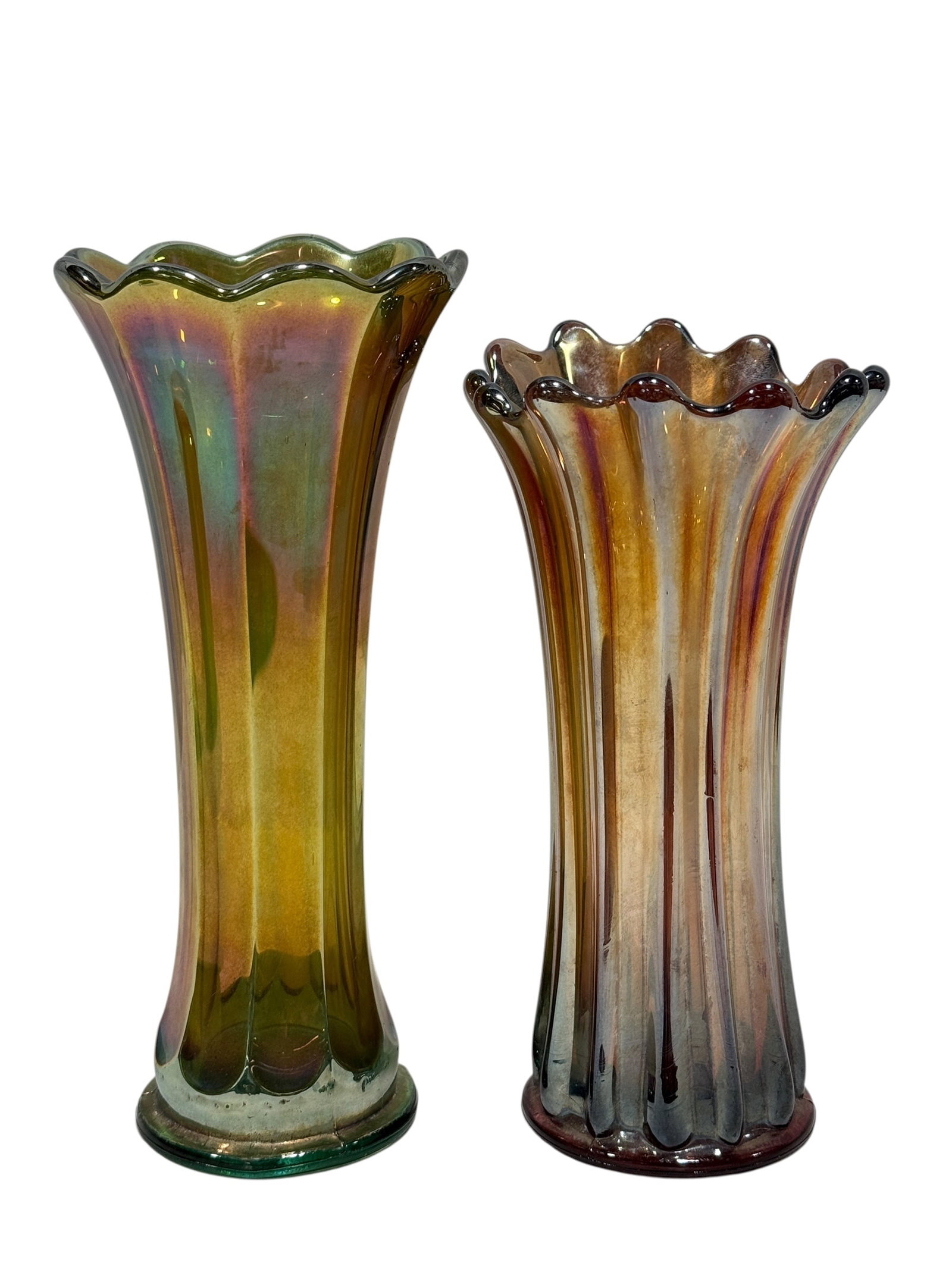 Pair of Vintage Iridescent Carnival Glass Ruffled Vases: A striking pair of tall vintage iridescent carnival glass vases, each molded with elongated vertical ribs and dramatically flared ruffled rims. One example is formed in a green-toned base glass with s