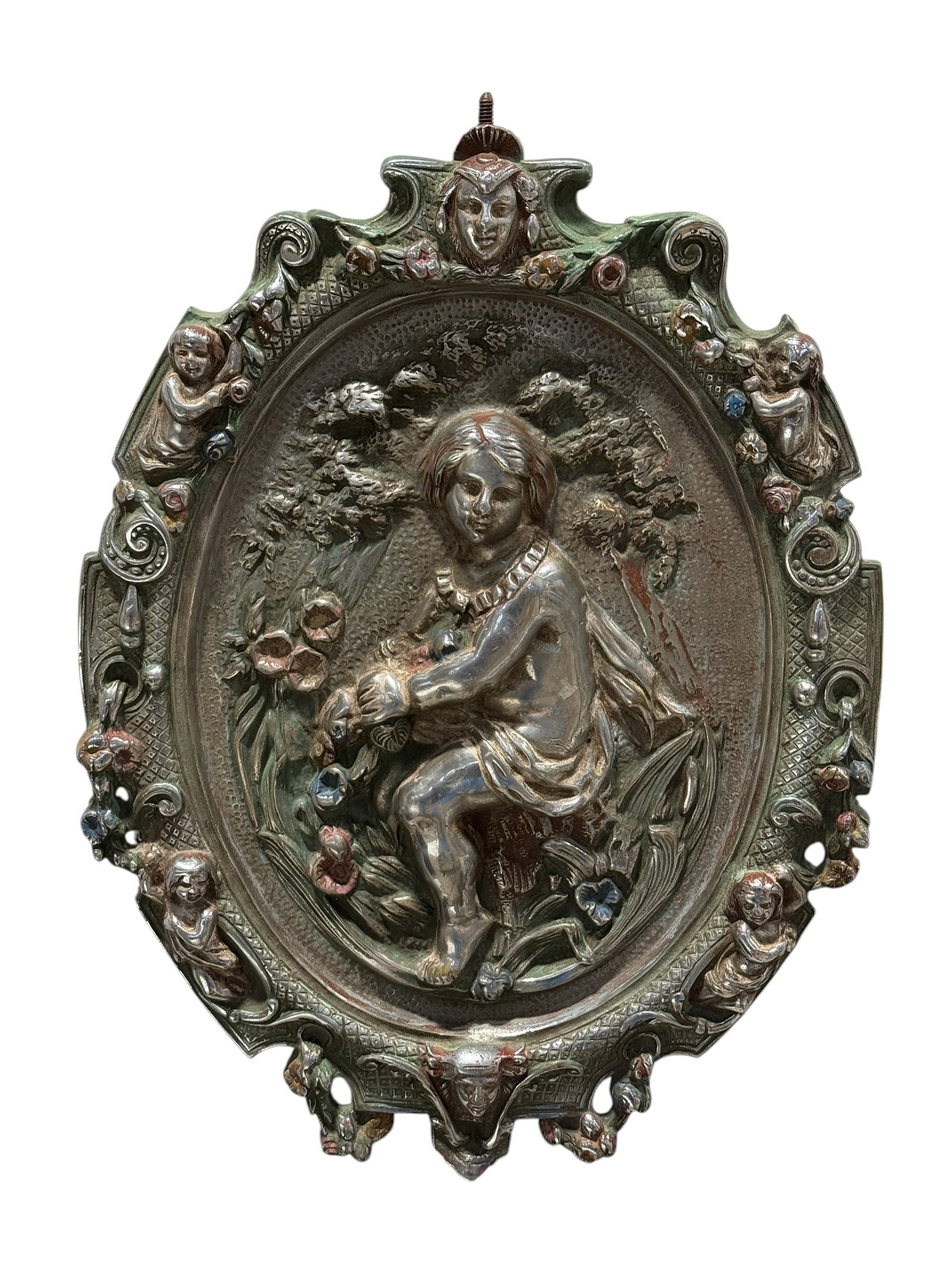 Antique Painted Brass Figural Relief Plaque w/ Child & Floral Decoration: Elaborately cast and painted brass wall plaque centered by a high-relief scene of a seated child gathering flowers beneath leafy trees, surrounded by a richly ornamented oval border populated with sma