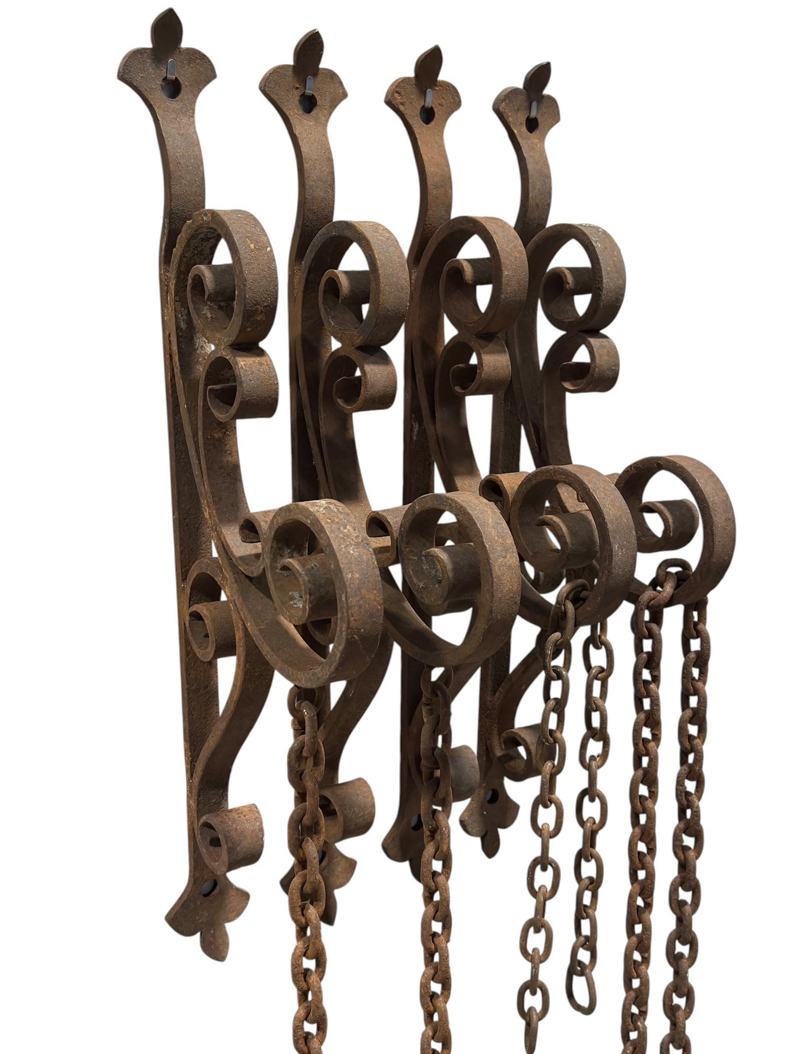 Pair of Antique Wrought Iron Scrollwork Wall Brackets w/ Chains: Decorative pair of antique wrought iron wall-mounted brackets featuring elaborate hand-forged scrolling forms with large volutes, curled terminals, and fleur-de-lis shaped mounting plates. Each bracke