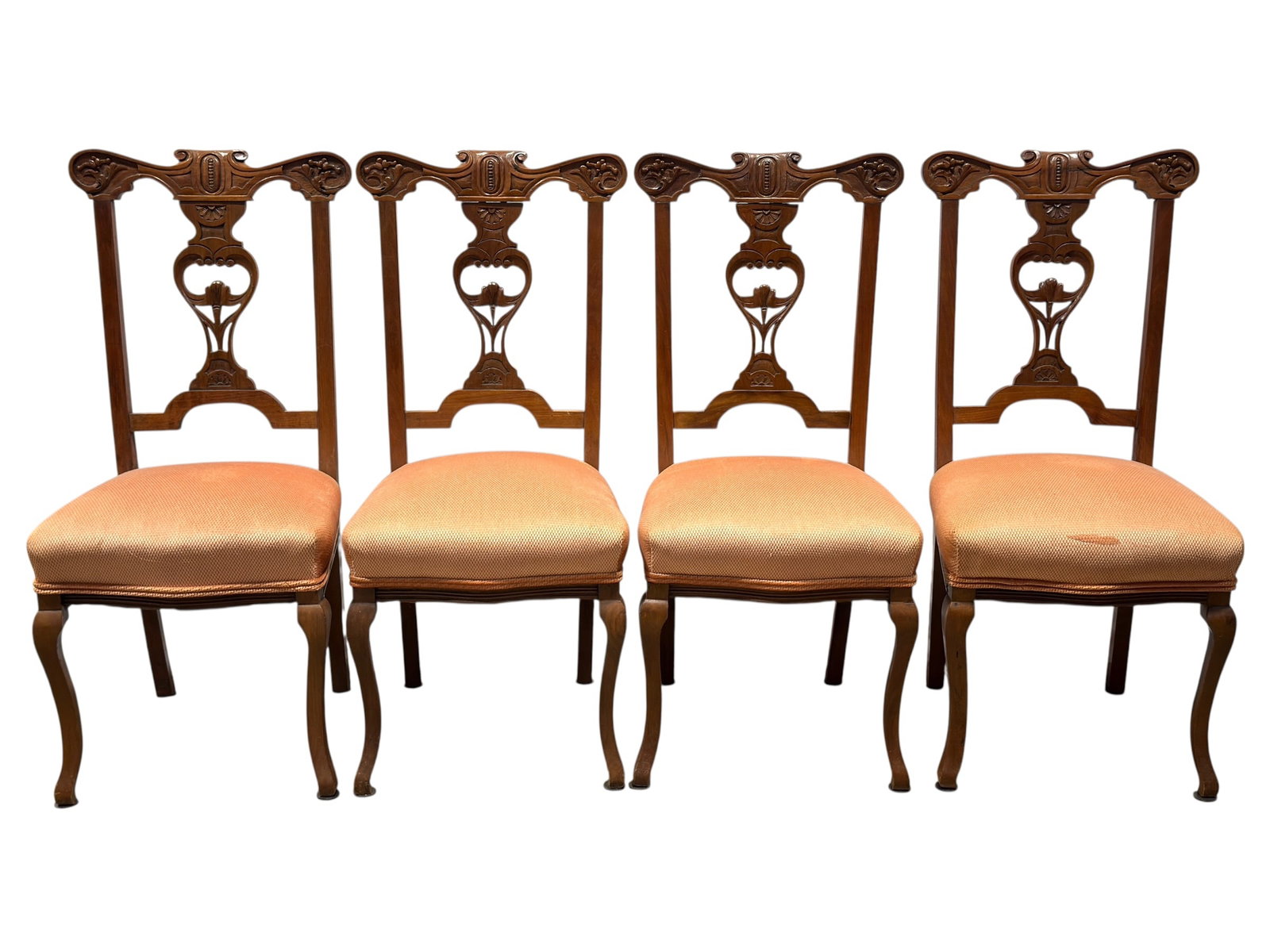Set of 4 Chippendale Style Carved Walnut Side Chairs: Set of four carved walnut side chairs in the Chippendale taste, each featuring a shaped and pierced back with scrolling crest rail, foliate carving, and a central carved splat incorporating a floral m