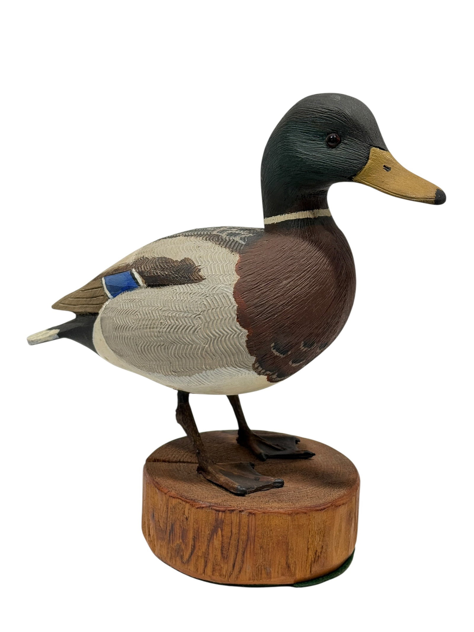 J.C. West, 1974, Hand-Carved & Painted Male Mallard Duck Sculpture: Hand-carved and painted wooden male mallard by J.C. West, dated 1974, modeled standing on carved feet atop a round wood slice base. The drake features inset glass eyes, a dark green-black head, warm c