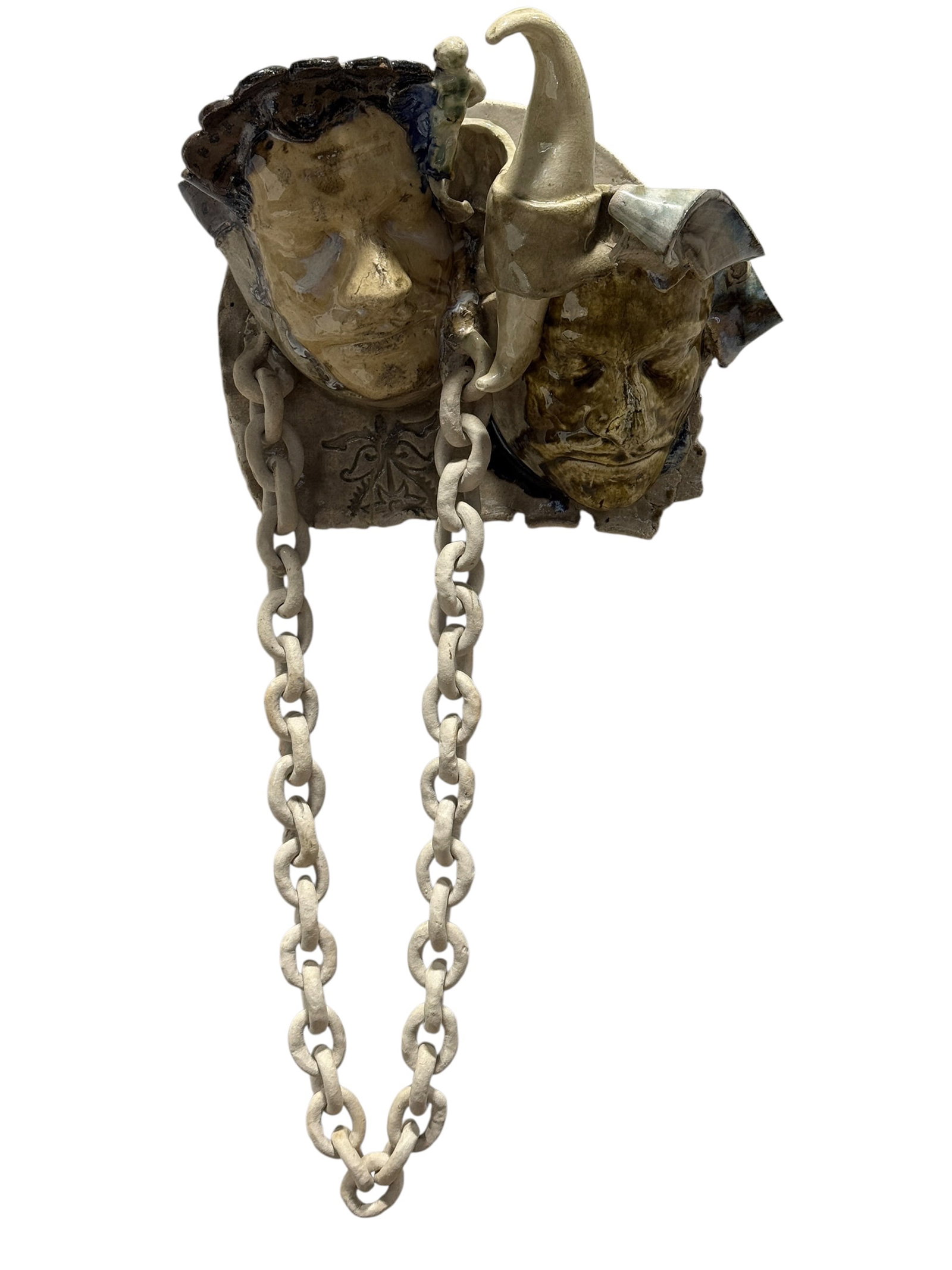Mid-Century Figural Pottery Jester & Grotesque Mask Wall Plaque: Expressive pottery wall plaque modeled with two adjoining theatrical faces, including a broad-faced figure beside a darker grotesque character wearing a tall curled jester-style cap. The sculptural co