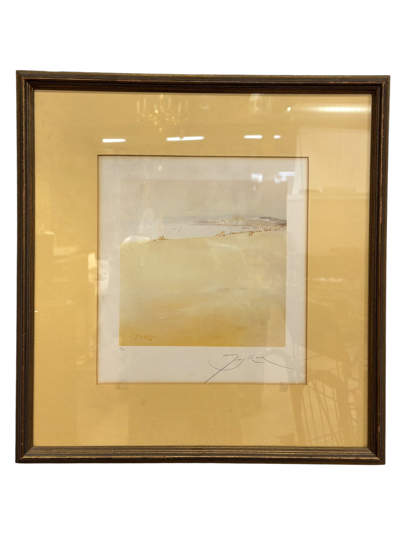 Signed Luigi Artist Proof Coastal Landscape Print: Softly rendered coastal landscape print depicting a broad sandy shoreline overlooking calm water, with distant buildings, small figures, and a sailboat emerging through a restrained palette of pale ye
