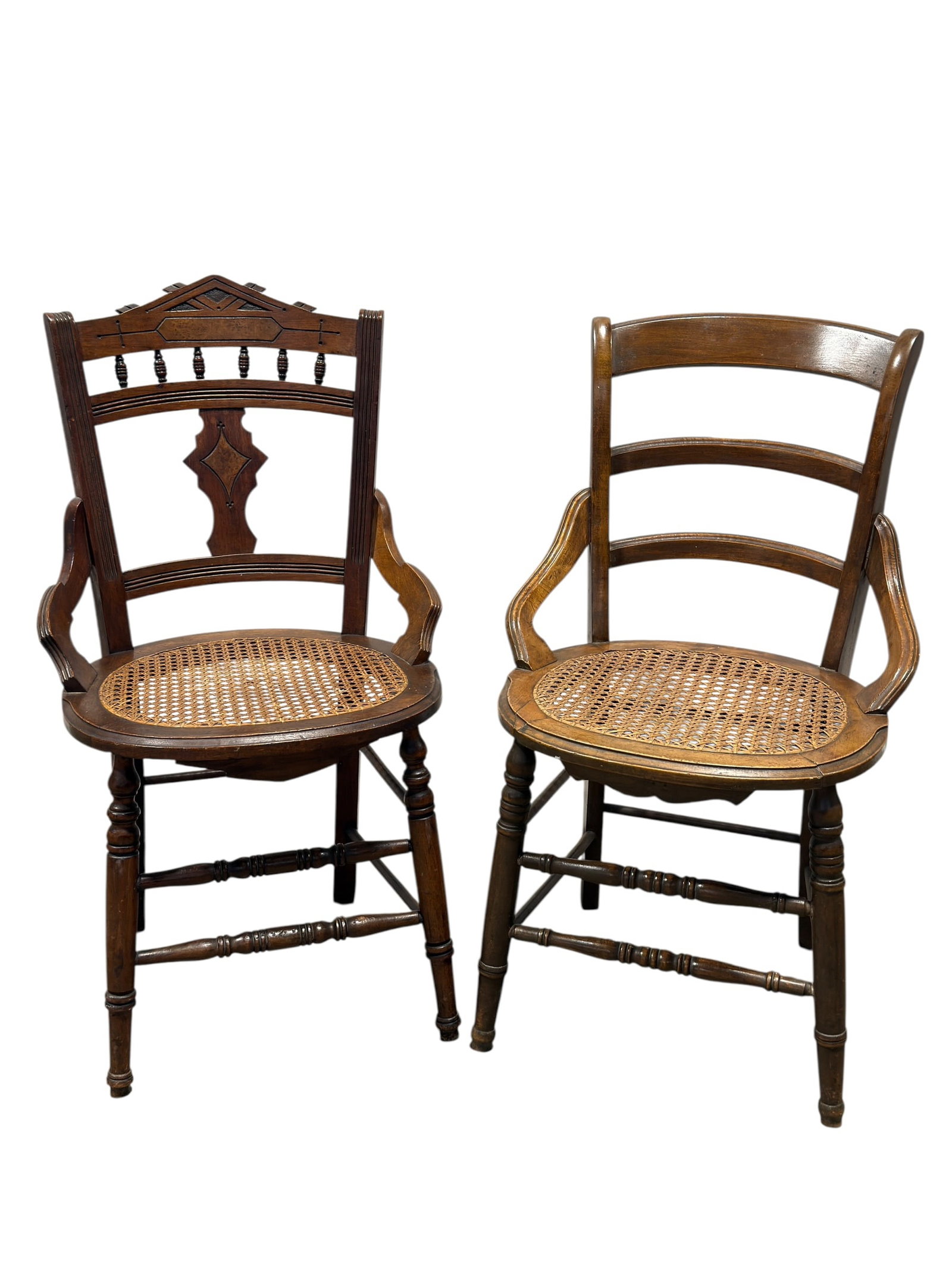 Pair of Late 19th–Early 20th C. Cane Seat Armchairs: Pair of antique wooden armchairs dating to the late 19th or early 20th century, offered together as an appealing mismatched pair unified by warm brown finishes, woven cane seats, shaped arms, and turn
