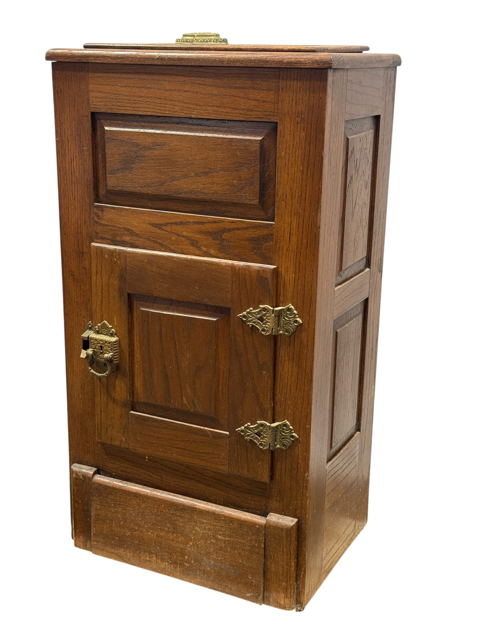 Antique Oak Ice Box Cabinet with Brass Hardware: Tall antique oak ice box cabinet dating to the early 20th century, constructed in richly grained oak with recessed paneling to the front and sides and fitted with decorative brass-tone hardware. The r