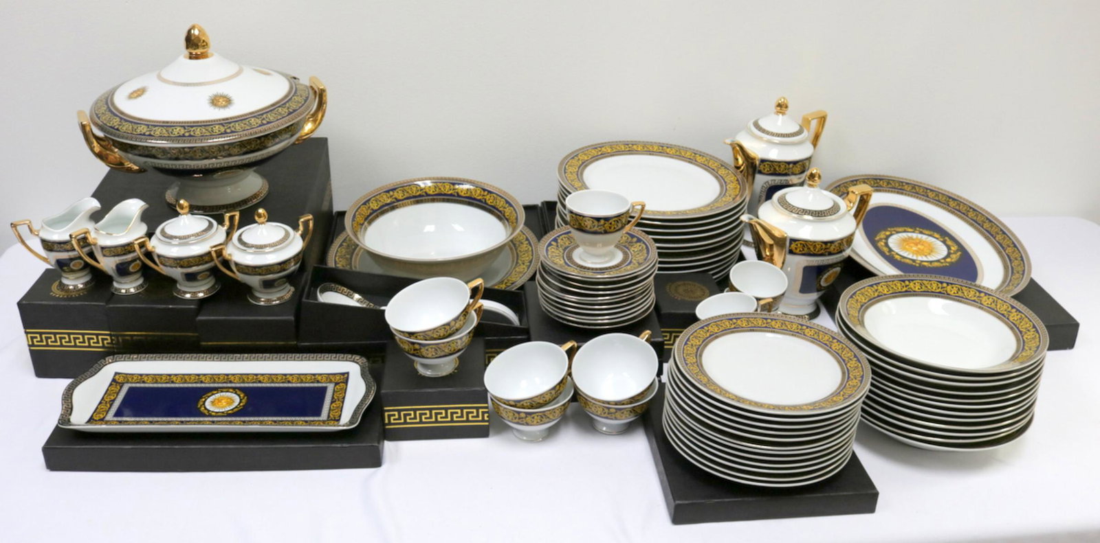 70 Pc. Versailles China Set: 70 Pc. Versailles China Set. In the style of Versace, Blue Medusa Head. This set contains 1 oval platter, 1 tea pot, 1 coffee pot, 12 dinner plates, 12 round soup bowls, 12 salad plates, 5 tea cups, 6