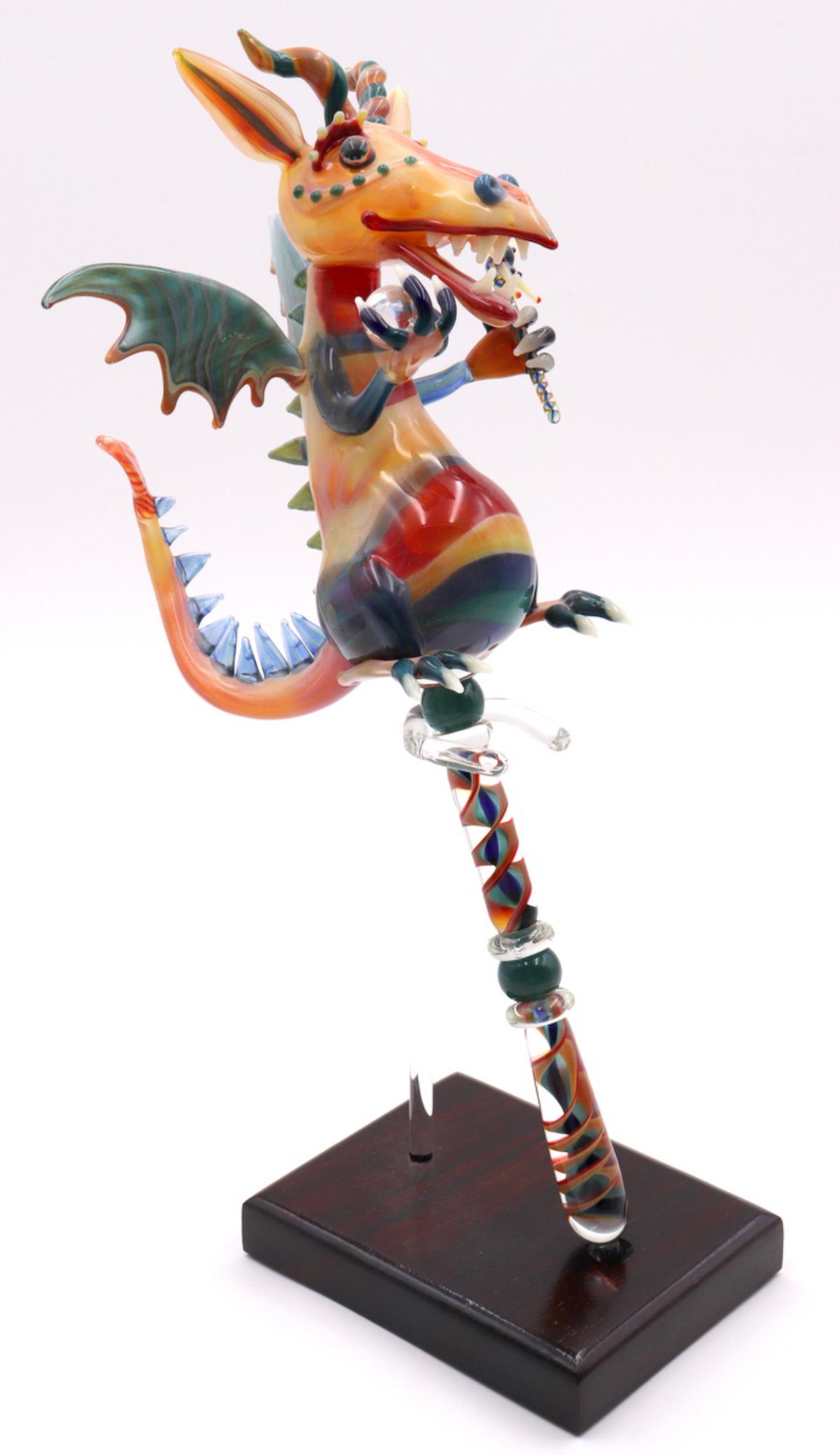 American Blown Art Glass Dragon Sculpture: American Blown Art Glass Dragon Sculpture on Base. Measures - 14" high x 9" wide including base. Highly detailed figure depicting a dragon holding a ball and a wand.