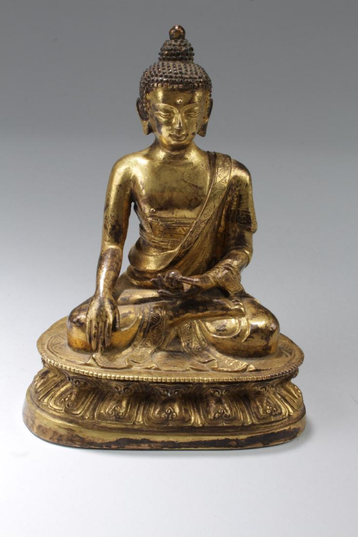 Chinese Gilt Bronze Buddha Statue: Seated in dhyanasana on a double-lotus throne, the hands held in the lap, wearing a sash and dhoti with chased borders, adorned with jewelry and a headdress, the face with a serene expression. Length: