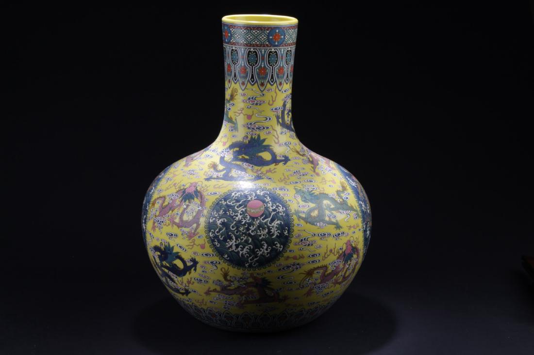 Chinese Famille Jaune porcelain Vase: The porcelain vase is painted with five-clawed dragons surrounded by scrolling clouds. A six character mark is imprinted at the bottom. Height: 20.5 "
