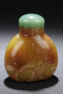 Chinese Stone Carved Snuff Bottle: Chinese stone carved snuff bottle, dome shaped stopper in pale green, round body with a mix of colors in browns, greens and yellows with natural stone veins running throughout. Height: 2.5"