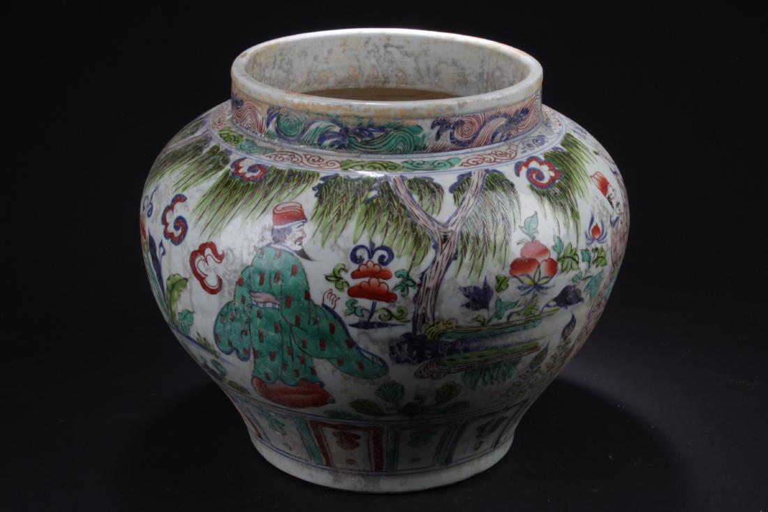 Chinese Wucai Porcelain Jar: Of broad shoulders and rising to a short neck, the porcelain jar is decorated with narrative scene of men and warriors in outdoor scenery. Height: 12"