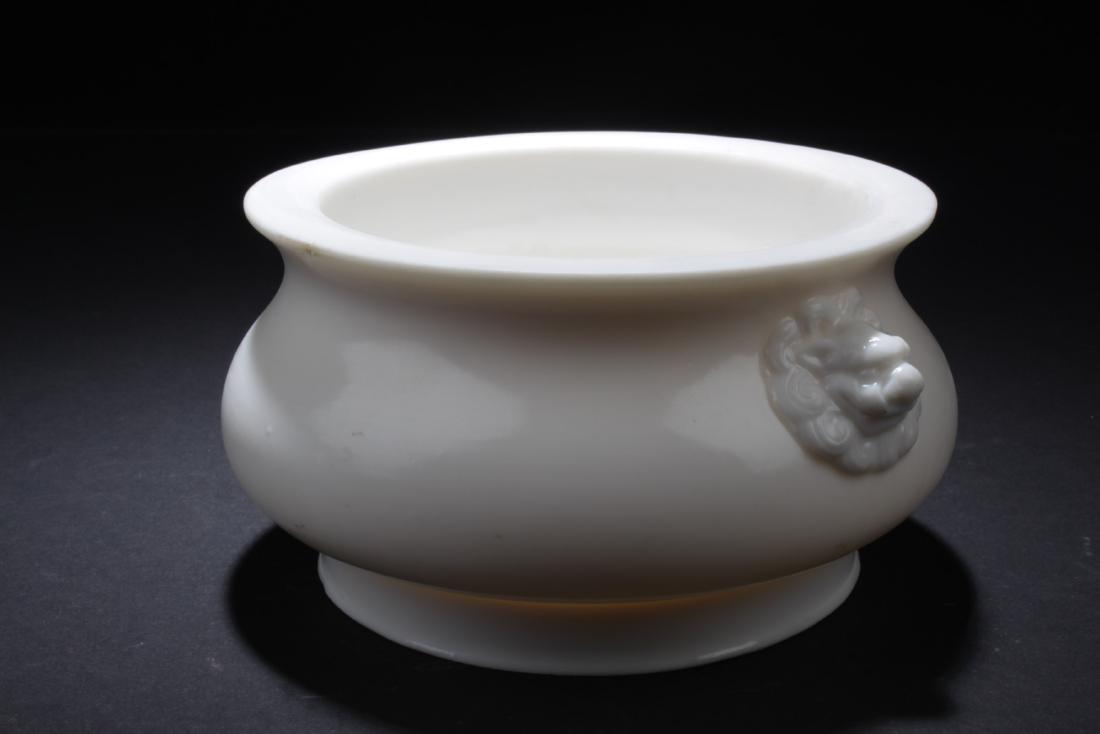 Chinese Blanc De Chine Censer: Chinese blanc de chine censer, flared rim, bulbous body on high footed base, small animal head ears at each side, plain white coloring throughout and dull finish. Height: 2.75"