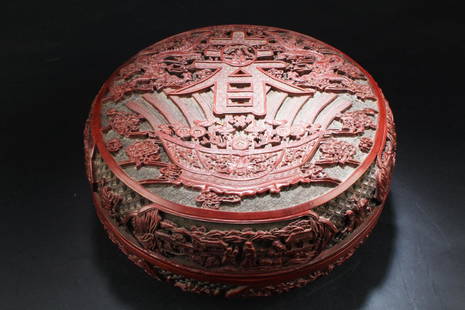 Chinese Cinnabar Lacquer Round Container: The cinnabar lacquer box is of compressed round form, exterior carved with two flying dragons amidst clouds surrounding Chun character, above stylized gold bullions, coins, and ingots, sides carved