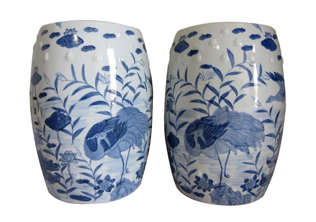 A Pair of Antique Chinese Blue and White Garden Seats: Chinese pair of blue and white garden seats, painted scene of birds flying through leafy vegetation and flowers, with white bosses at the top and pierced emblems throughout. Height: 18.5 ", Width: 11 