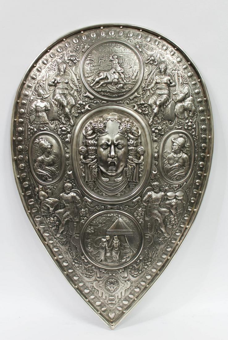 A LARGE AND IMPRESSIVE SILVERED COPPER SHIELD: A LARGE AND IMPRESSIVE SILVERED COPPER SHIELD OF FRANCESCO I DE MEDICI, 19TH CENTURY, AFTER THE ORIGINAL BY BENVENUTO CELLINI (ITALIAN 1500-1571). At center of the concave form shield a high relief sc
