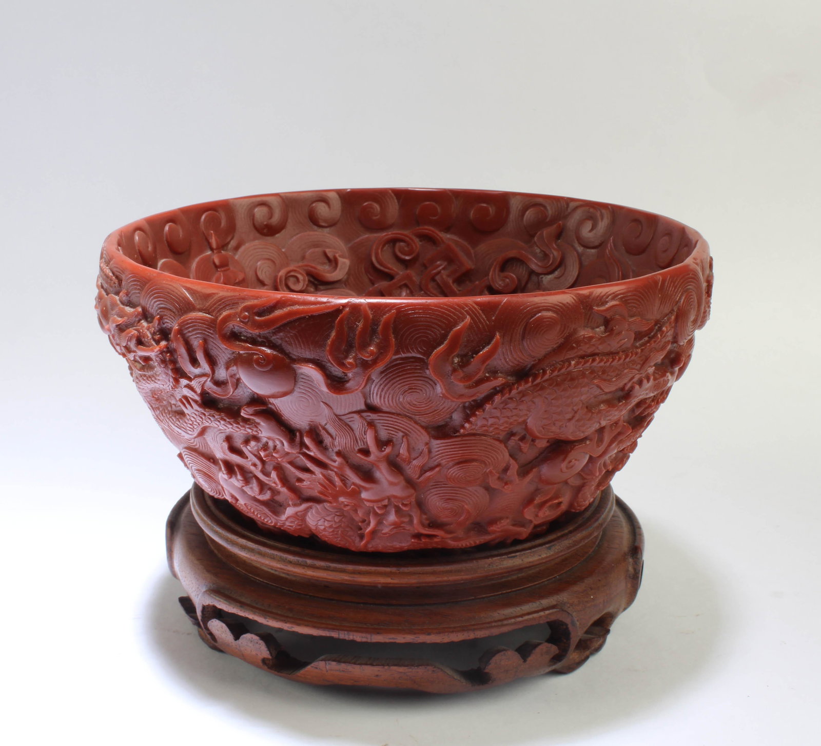 A Carved Chinese Bowl: A Carved Chinese Bowl. Comes fitted with a wooden stand. Diameter: 6"