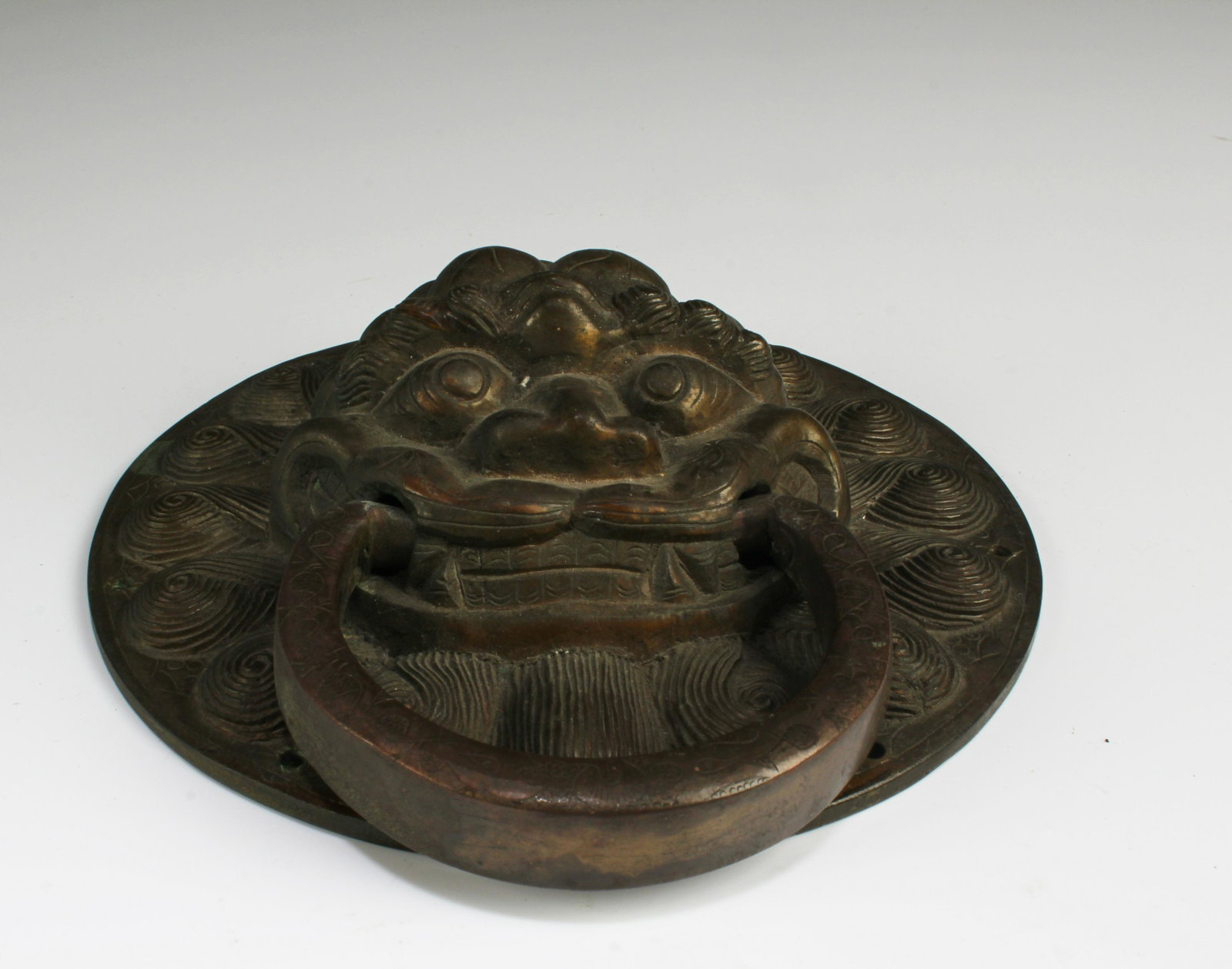 A Bronze Door Knocker: A Bronze Door Knocker. Diameter: 6.5"