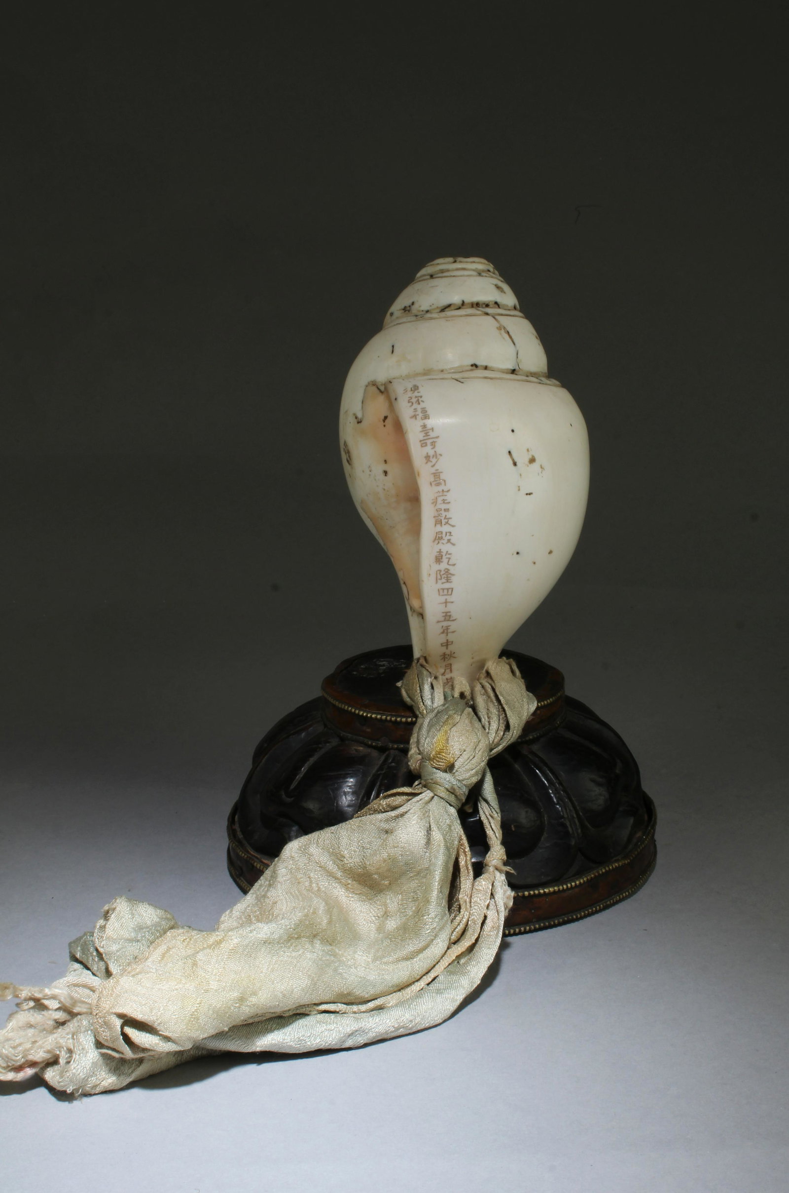 A Carved Shell Ritual instrument: A Carved Shell Ritual instrument. 'QianLong' mark. Comes with a stand. Height: 8.3" (include stand) Diameter (stand): 6"