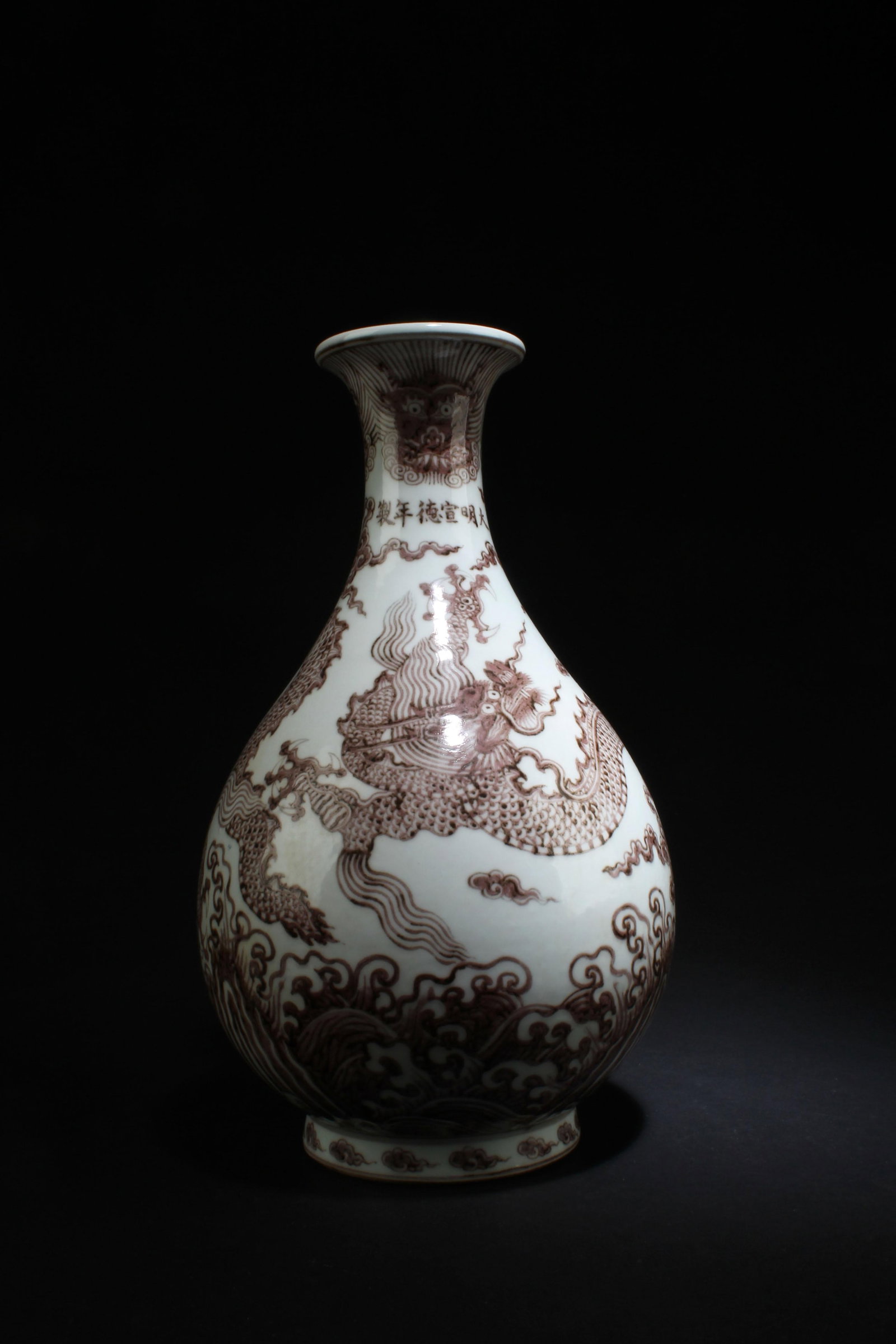An Iron Red Dragon Porcelain Pear-shaped Vase: An Iron Red Porcelain Vase, decorated with a dragon and big, turbulent waves. 'XuanDe' mark. Height: 13.1"