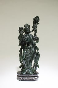 A Carved Spinach Green Guanyin Statue