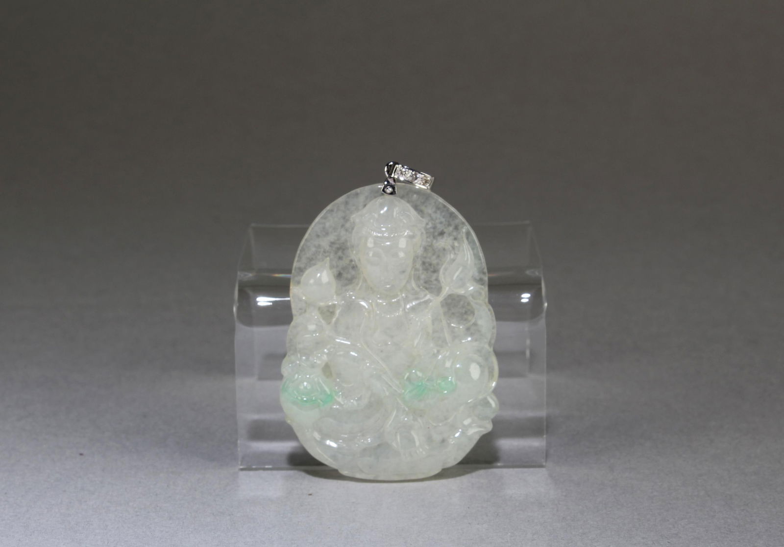 A Carved Jadeite Jade Guanyin Pendant: A Carved Jadeite Jade Guanyin Pendant, with a white gold hook, with three small diamonds. Length: 2"