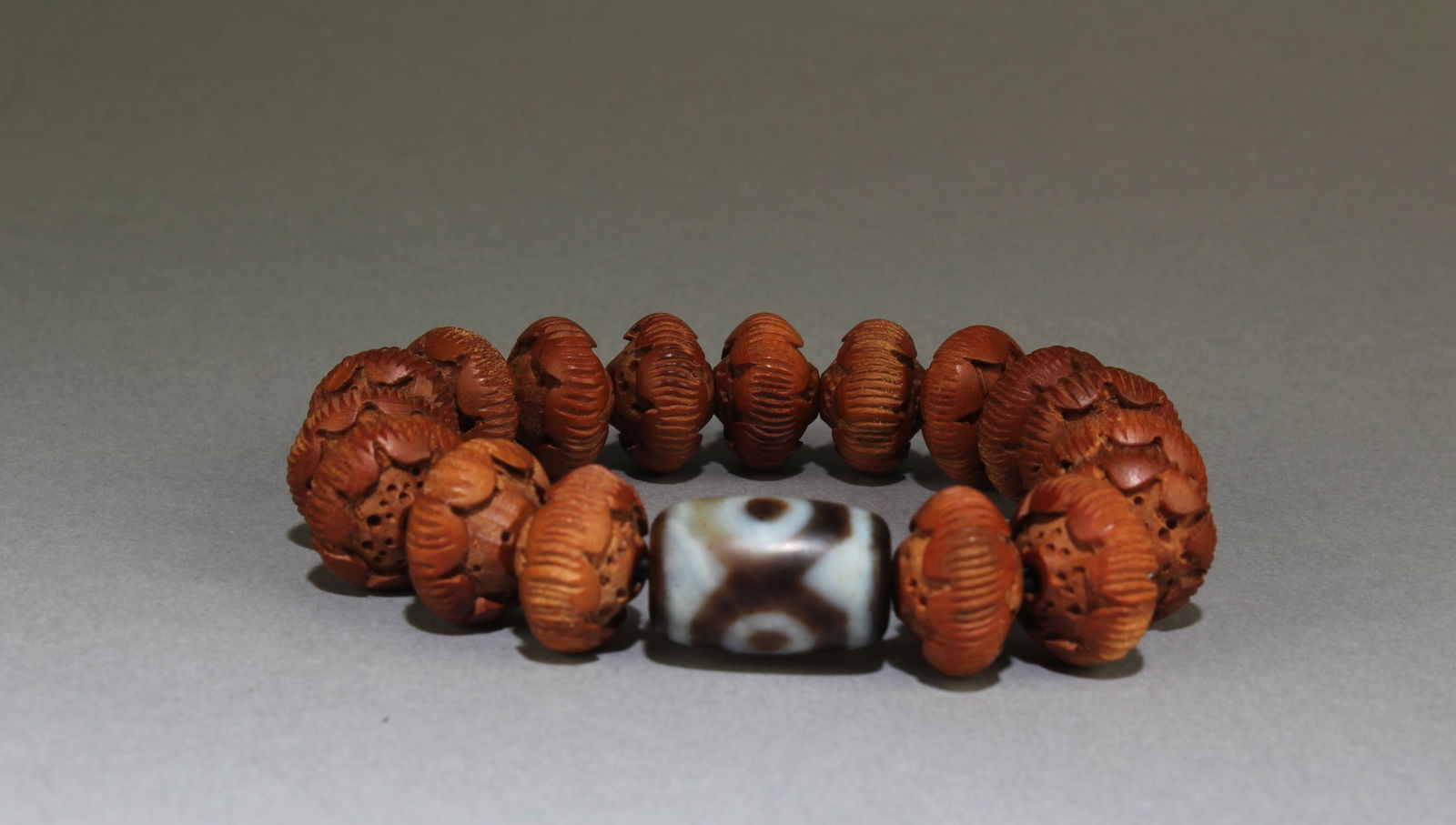 Antique Dzi (Three Eye)Bracelet: Antique Dzi (Three Eye) Bracelet, with carved woden lotus beads. Diameter: 0.7" (Dzi bead)
