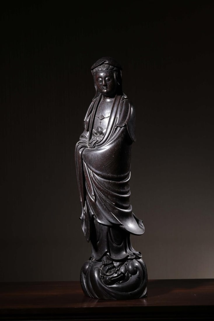 A Zitan Wood Guanyin Statue: A Zitan Wood Guanyin Statue. Height: 20.79in; Width: 6.30in; Thickness: 4.53in; Weight: 22.928lb.