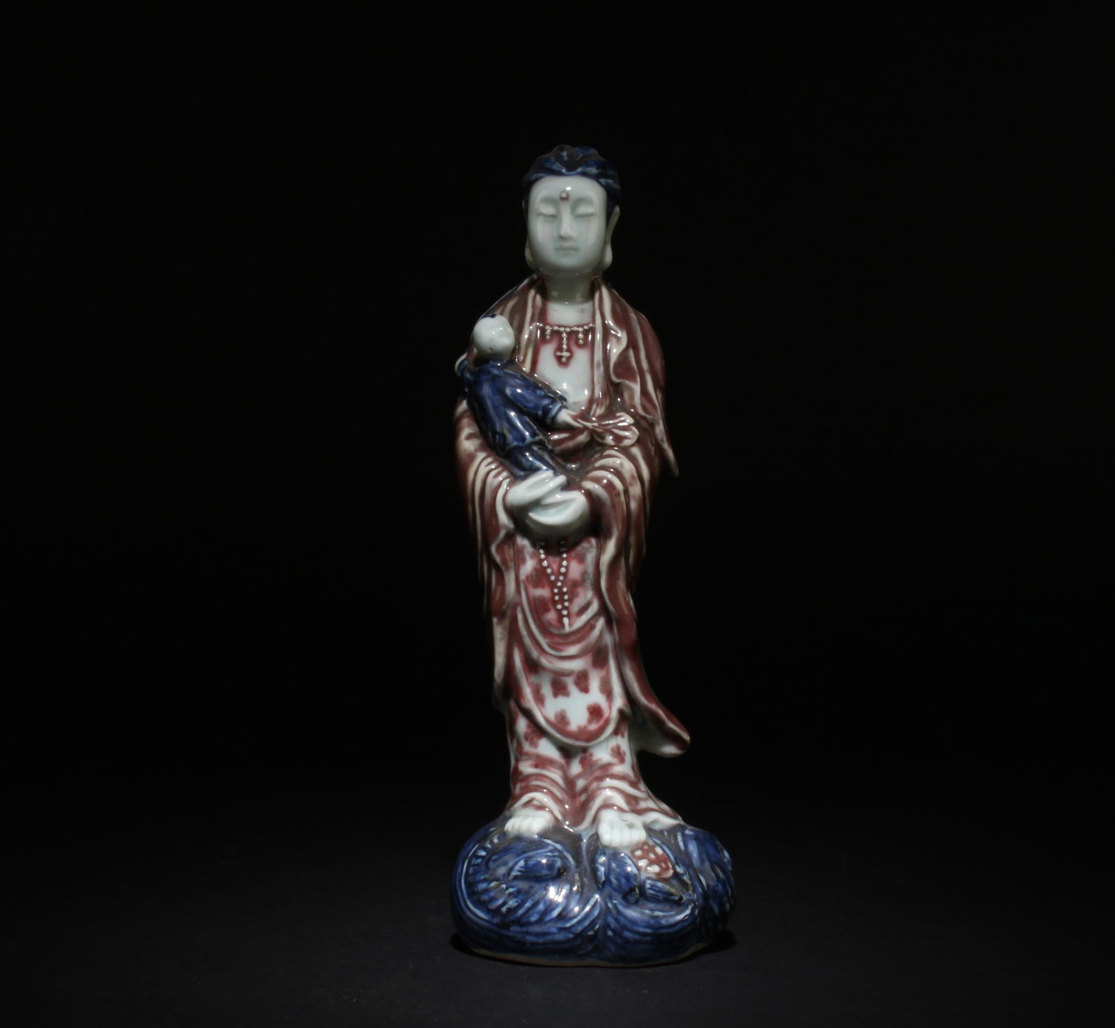 A Blue and Underglazed Red Guanyin Statue: A Blue and Underglazed Red Guanyin Statue. Dimensions: 10" x 3.75".