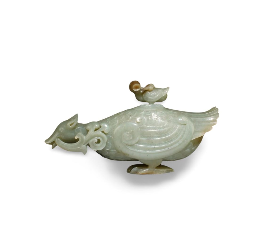 Chinese Jade Carved Ornament: A beautifully carved jade ornament, depicting a duck on top of a mammal, showing intricate details of its feathers, feet. Length: 8 in Height: 4.5 in