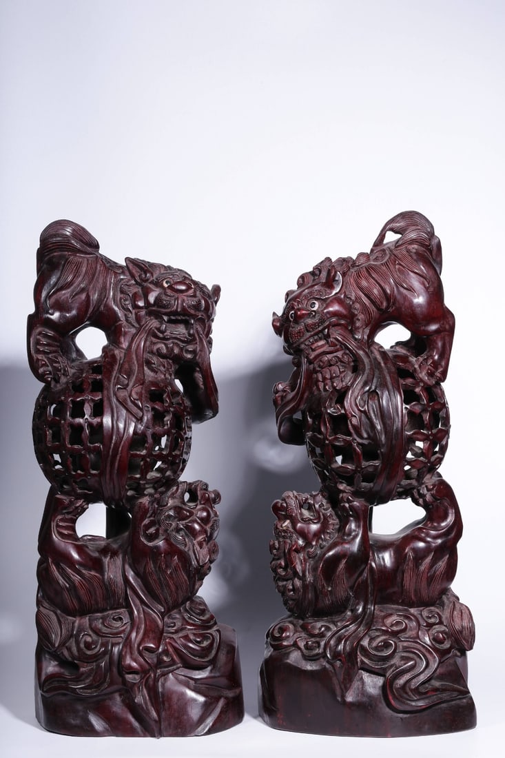 A Pair of Zitan Wood Lion Ornaments: A Pair of Zitan Wood Lion Ornaments. Height: 19.69in; Length: 7.87in; Width: 4.33in; Weight: 12.58lbs.
