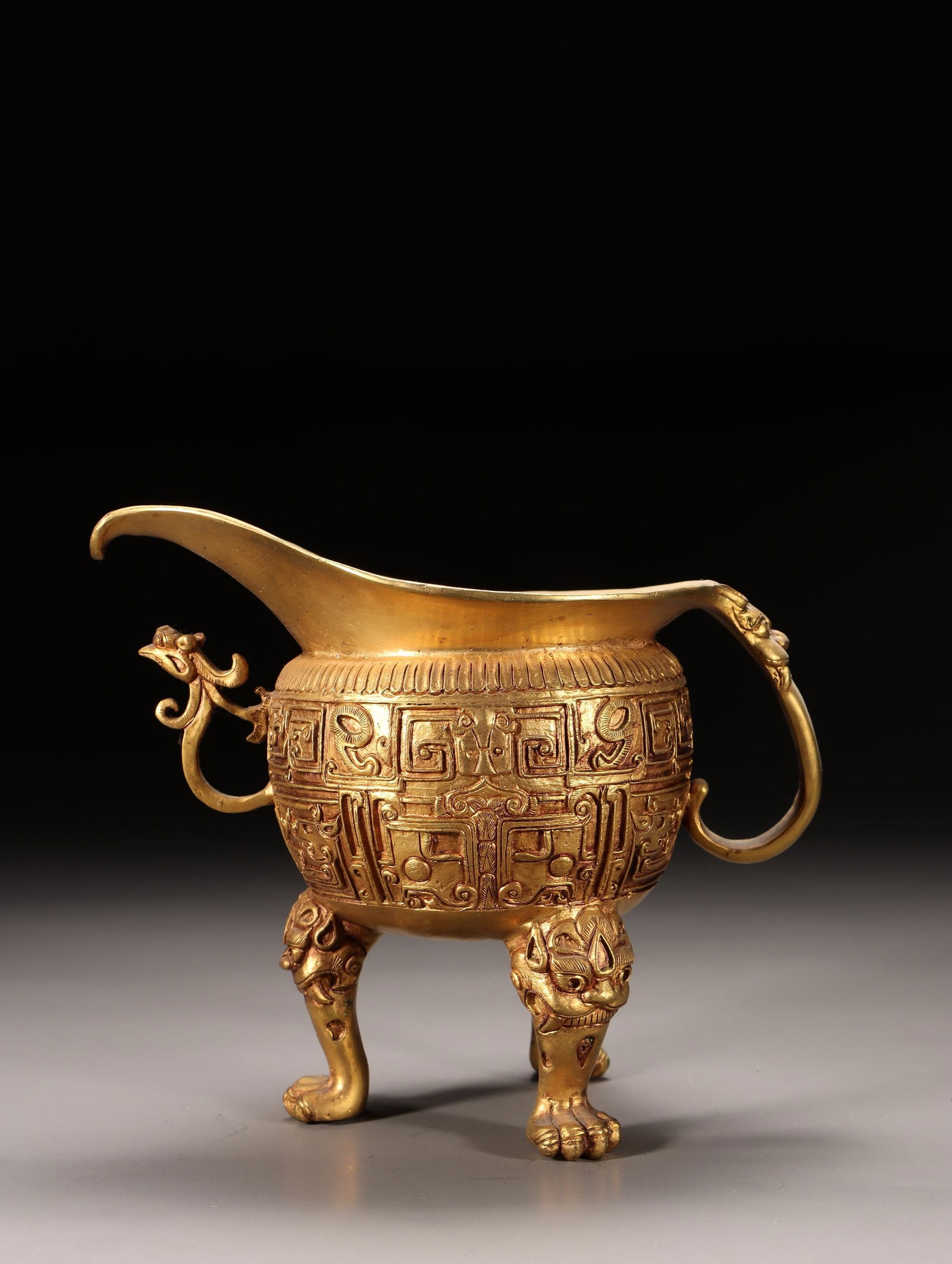 A Gilt Bronze Tripod Jue Cup: A Gilt Bronze Tripod Jue Cup. Dimensions: 5.71 × 7.48 × 4.33 in; Weight: 2.924 lb.