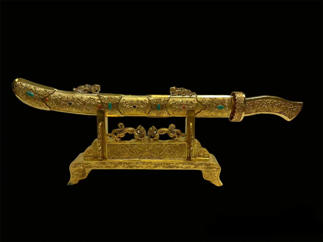 A Gilt Bronze Decorative Swords: A Gilt Bronze Decorative Sword. Seal Mark on the hilt. The Scabbard is decorated with turquoise stones. Comes with a sword stand. Length: 28.5" (Sword complete with scabbard) Length: 15.75" Width: