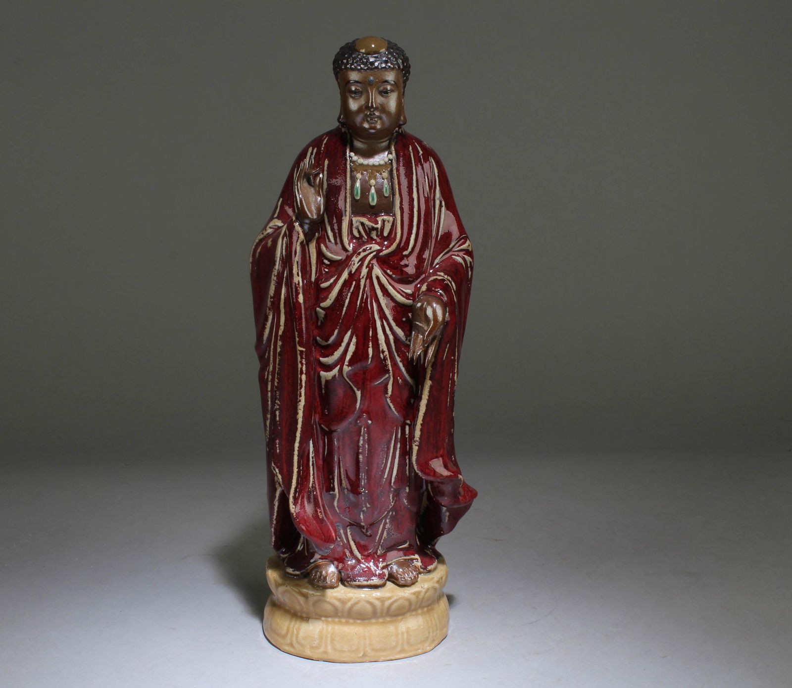 A Chinese Ox-Blood Red Glazed Statue: A Chinese Ox-Blood Red Glazed Standing Buddha Statue. Dimension: 11.5" x 4.75" x 3.75".