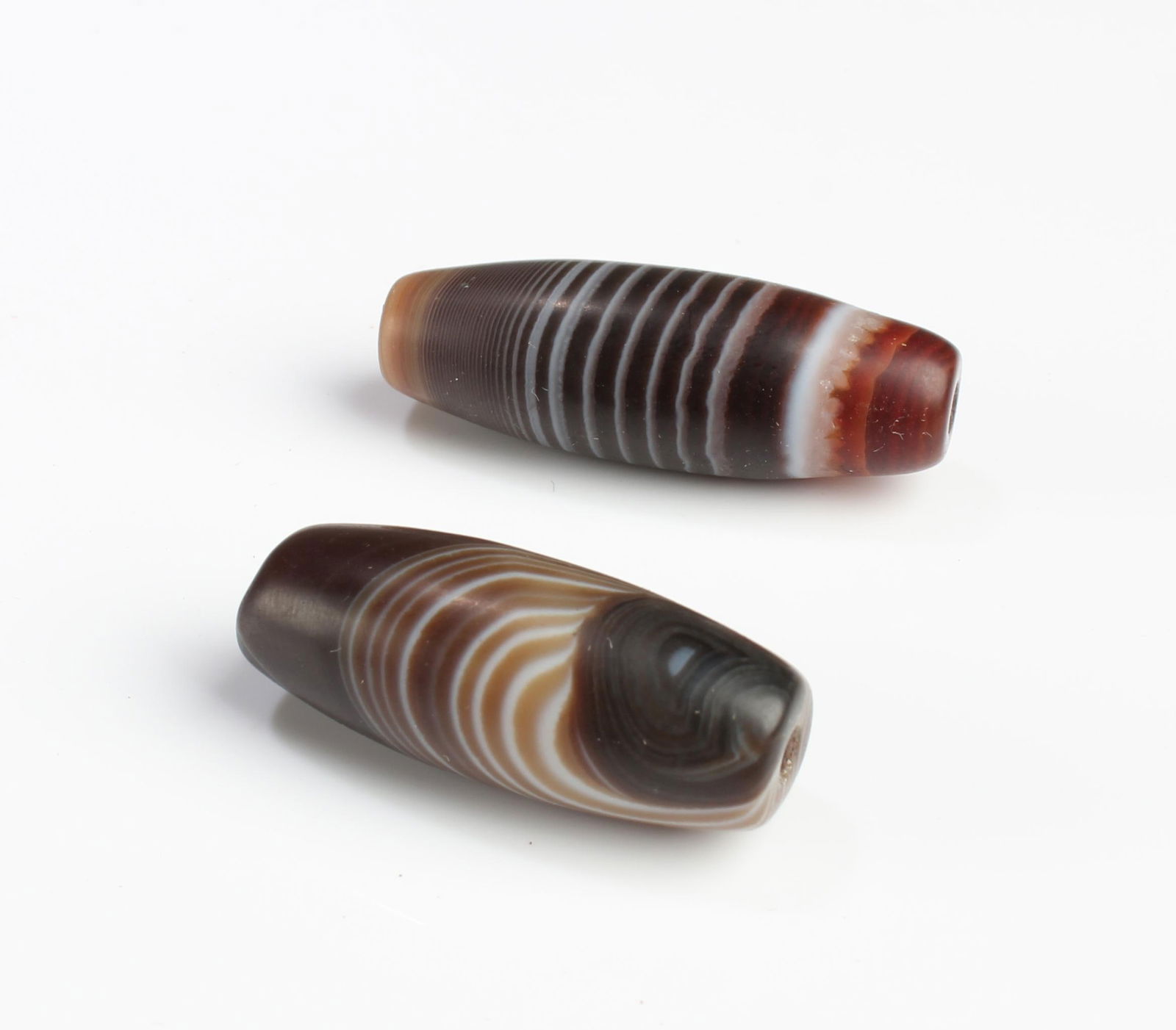 A Group of Two Dzi Beads: A Group of Two Dzi Beads. Length: 1.25" (longer)