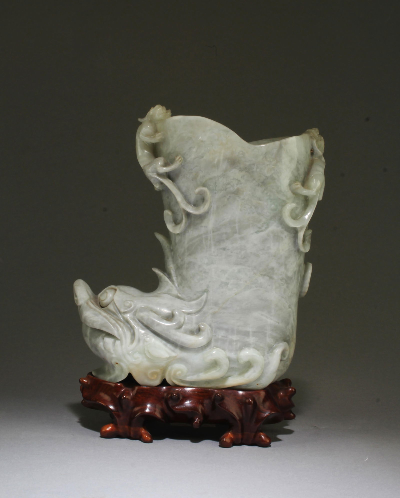 A Carved Jade Brushpot: A Carved Jade Brushpot. Comes fitted with a wooden stand. Height: 7"