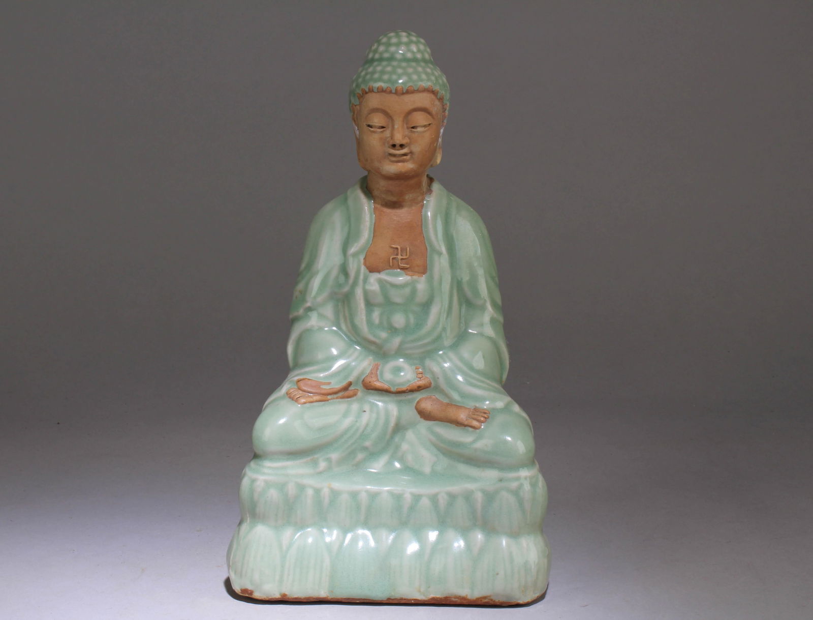 A Longquan Celedon Colored Buddha Statue: A Longquan Celedon Colored Buddha Statue. Dimension: 9.75" x 5.75" x 4".