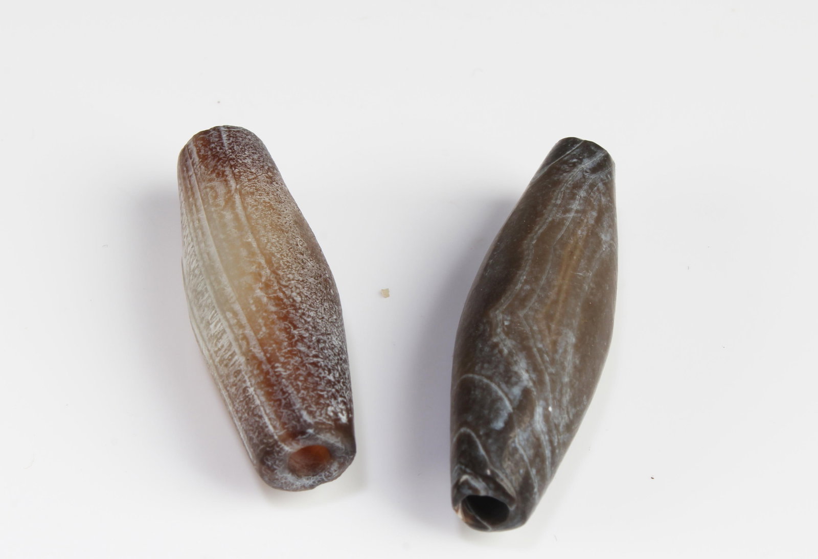 A Group of Two Tibetan 'First-Line' Dzi Beads: A Group of Two Tibetan 'First-Line' Dzi Beads. Length: 1.25"