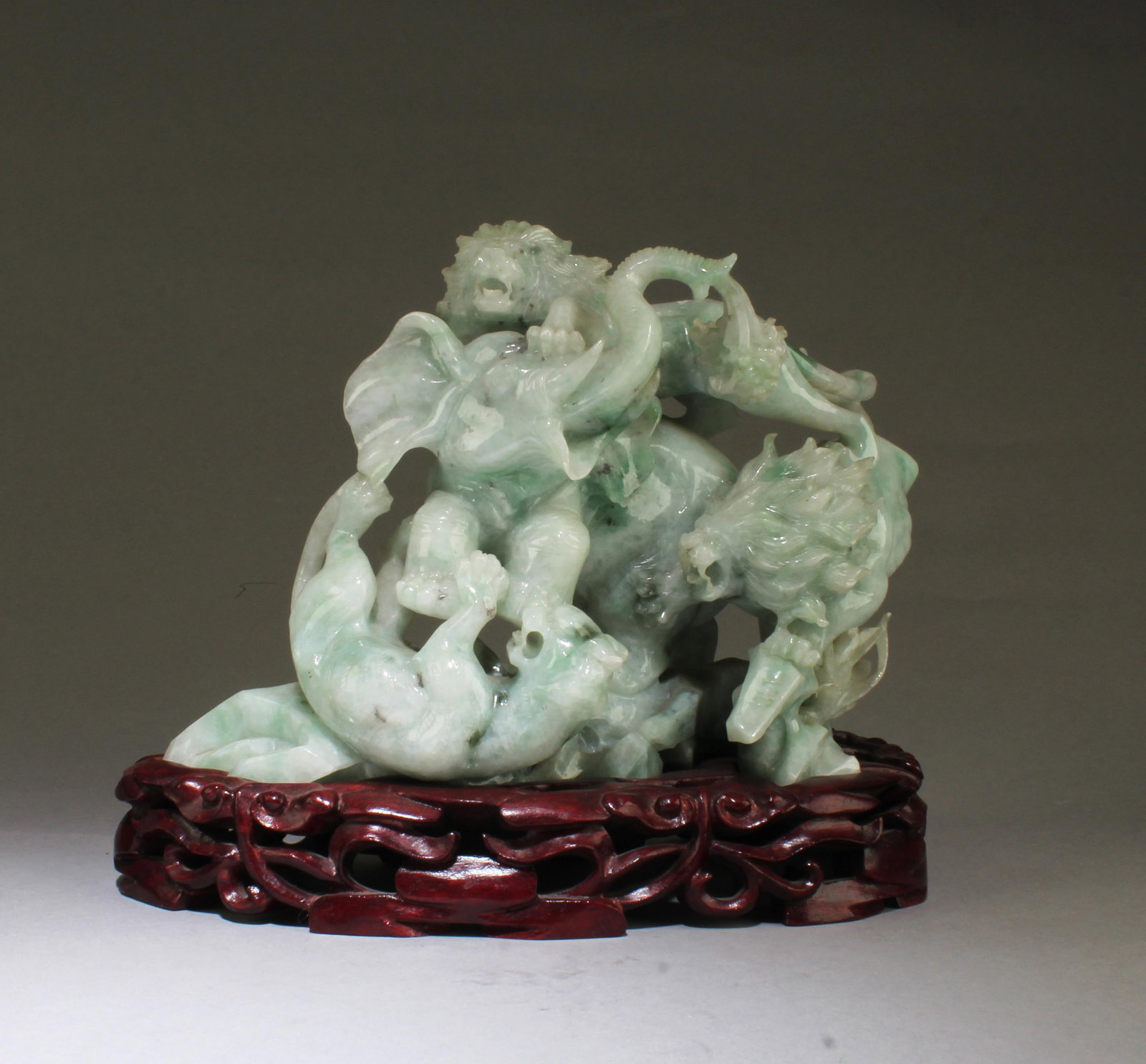 A Chinese Carved Jade Figurine: A Chinese Carved Jade Figurine. Comes fitted with a wooden stand. Length: 8.25"