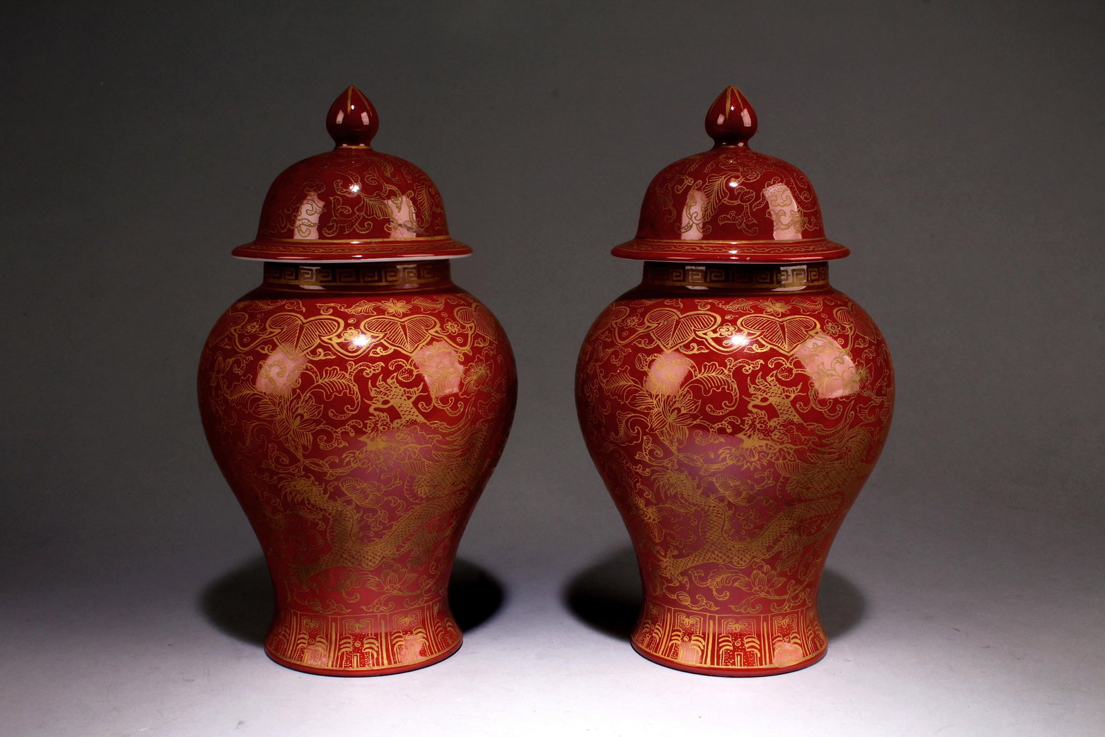 A Pair of Red Vases: A Pair of Red Vases. A Pair of Red Vases, the body decorated with five clawed dragons, come with lid. "QianLong" mark at base. Dimensions: 9.5" x 5".