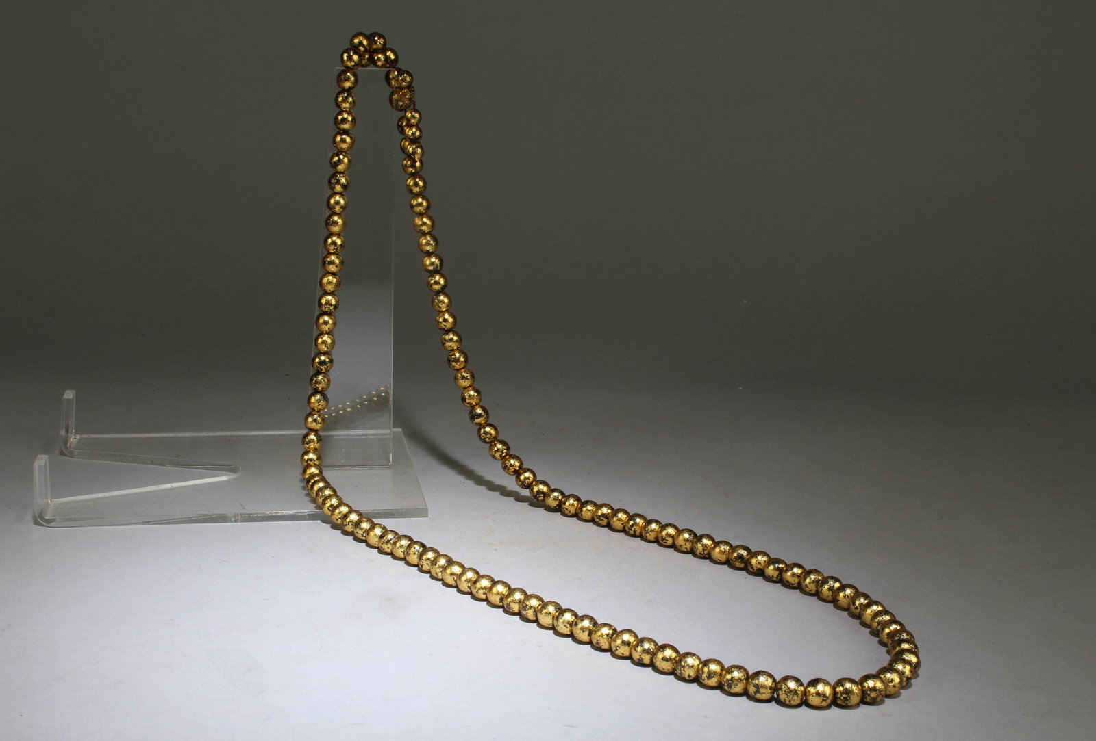 A Gold Pasted Agarwood Necklace: A Gold Pasted Agarwood Necklace. Dimension: Connected Top to Bottom Height: 20.75" .