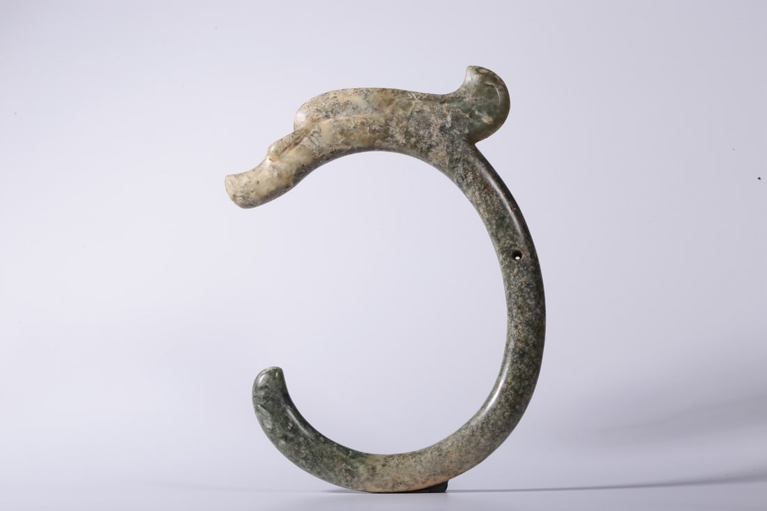 An Archaic Jade C-Dragon: An Archaic Jade C-Dragon. Dimensions: 8.66in x 6.30in x 0.59in; Weight: 0.85lbs.