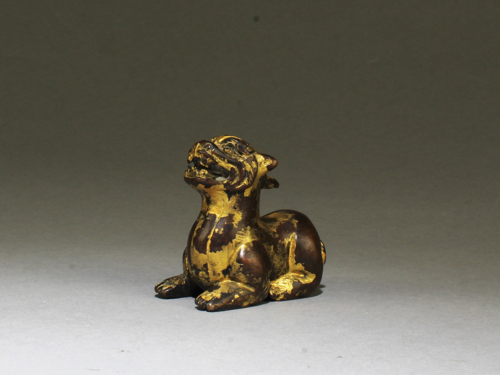 Chinese Gilt Bronze Ornament: Chinese Gilt Bronze Ornament, depicting an intricately carved mythical beast. Length: 2 "