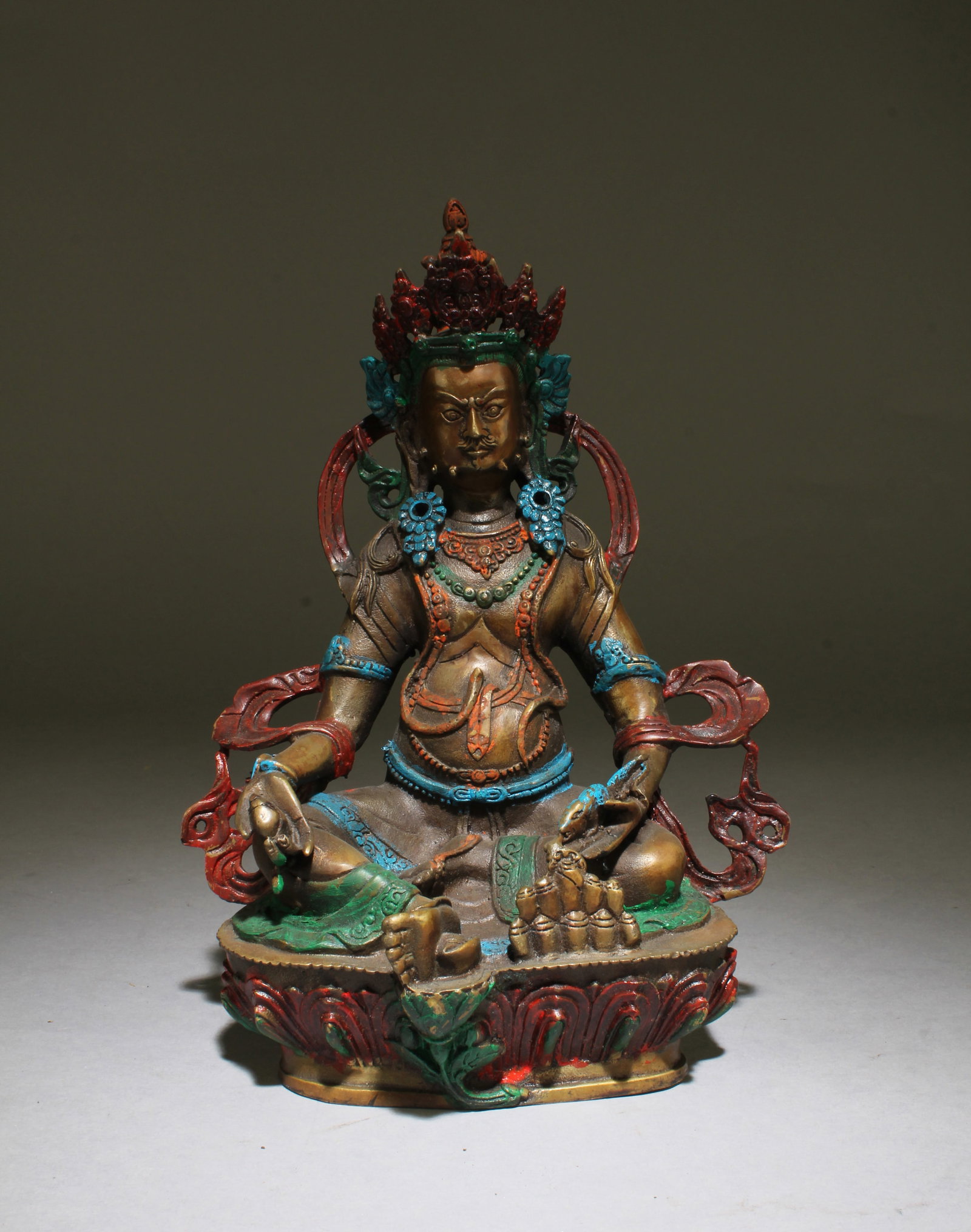 Chinese Tibetan Bronze Bodhisattva Statue: Seated with legs crossed and right leg resting on an extended lotus platform, both hands holding religious instruments, chest adorned with beaded jewelry, wearing a headdress. Height: 8"