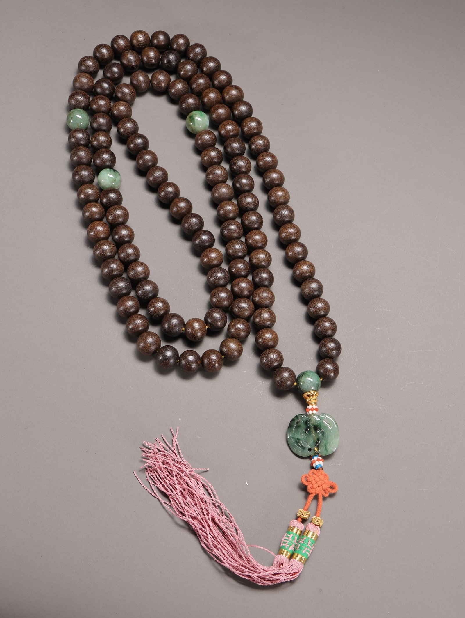 An Agarwood and Jade Prayer Bead Strand: An Agarwood and Jade Prayer Bead Strand. Diameter: 0.55". Weight: 0.38lbs.