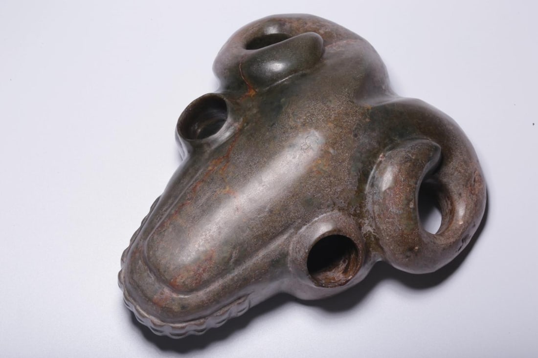 An Archaic Jade Mask: An Archaic Jade Mask. Length: 7.87"; Width: 6.50"; Height: 3.15". Weight: 4.64lbs.