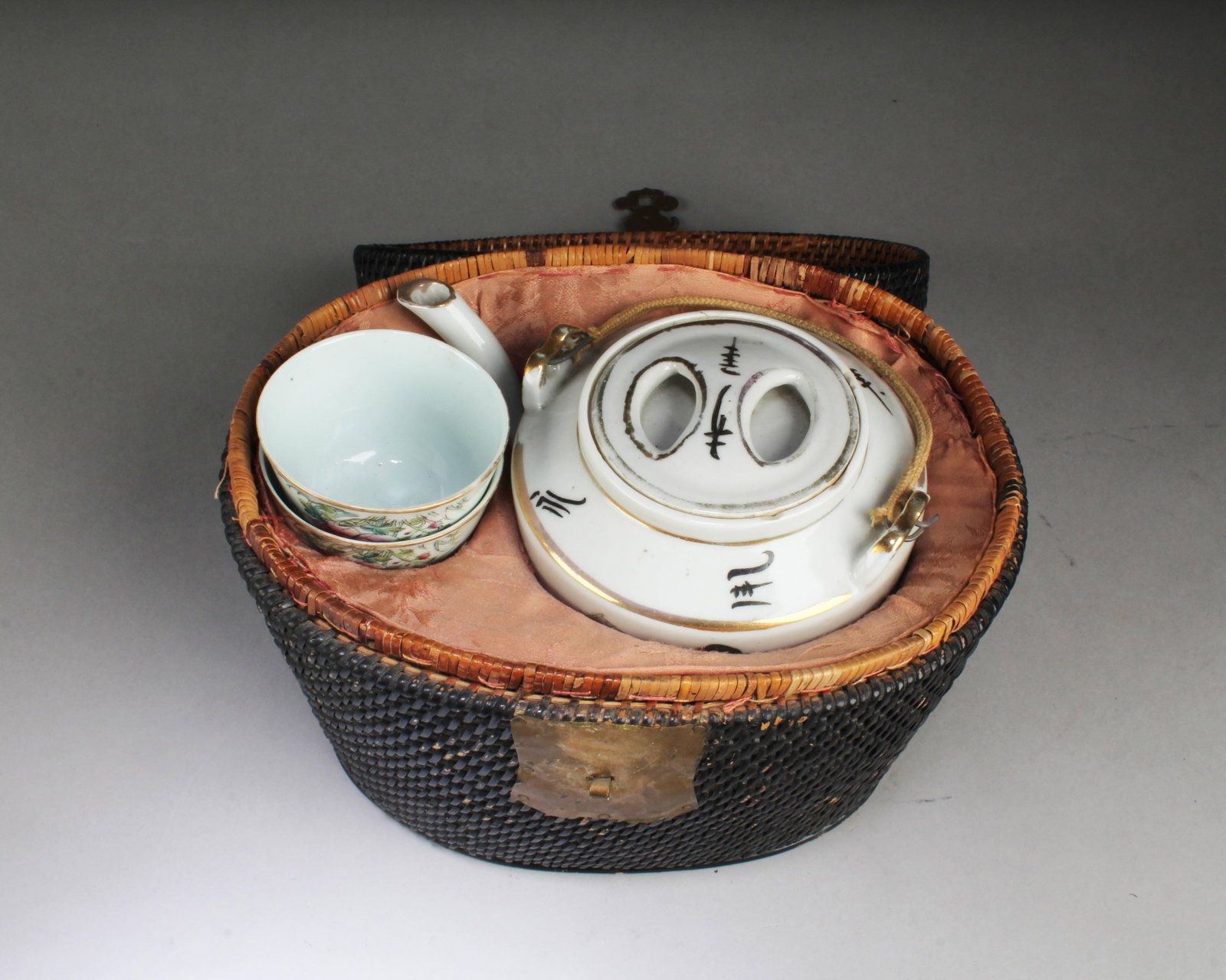 Antique Teapot with 2 Cups encased in Box: Antique Teapot with 2 Cups encased in Cane Weaved Box. Length: 10" Height: 7.25" (Box)