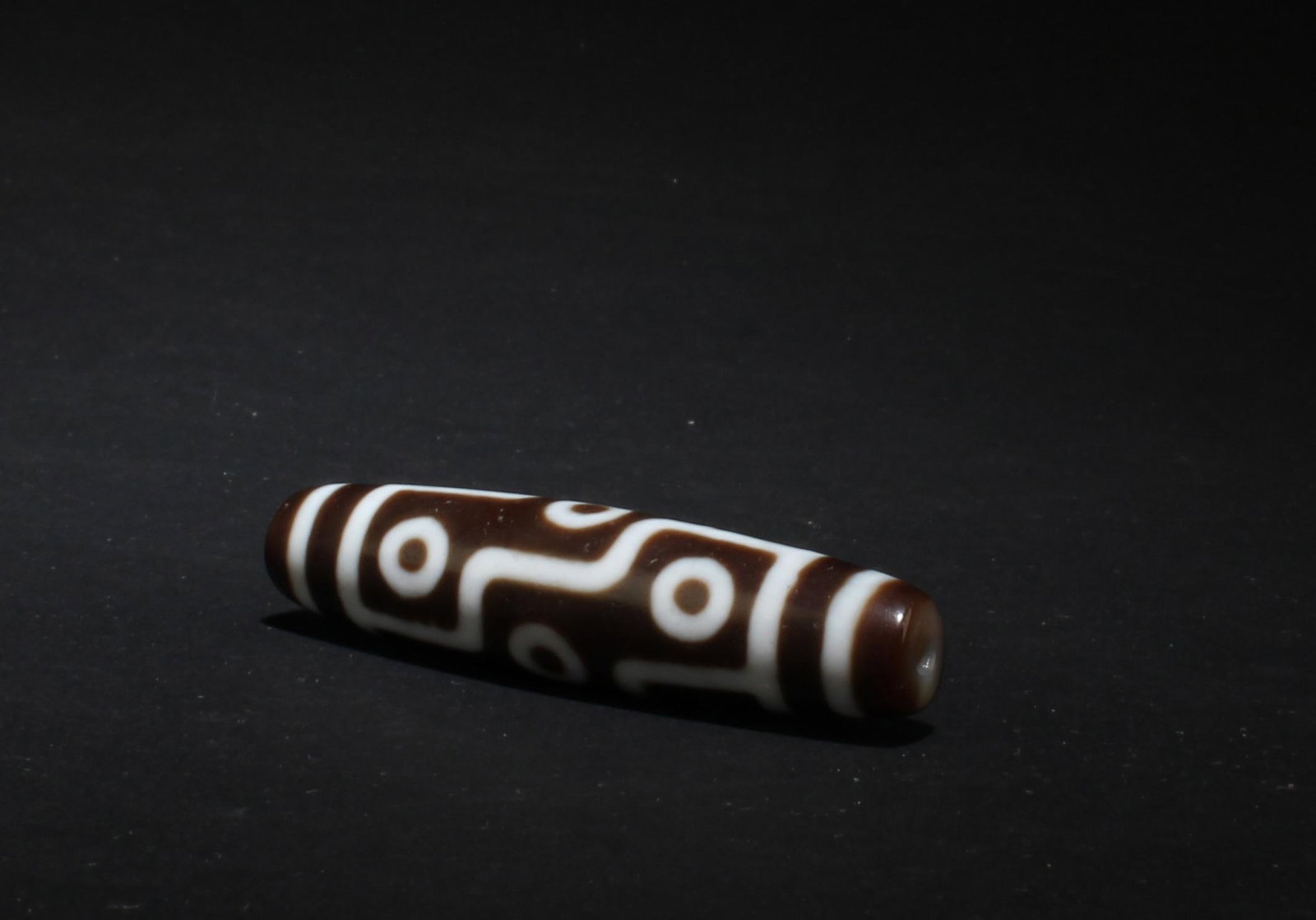 A Dzi Bead: A Dzi Bead. Length: 2.2"